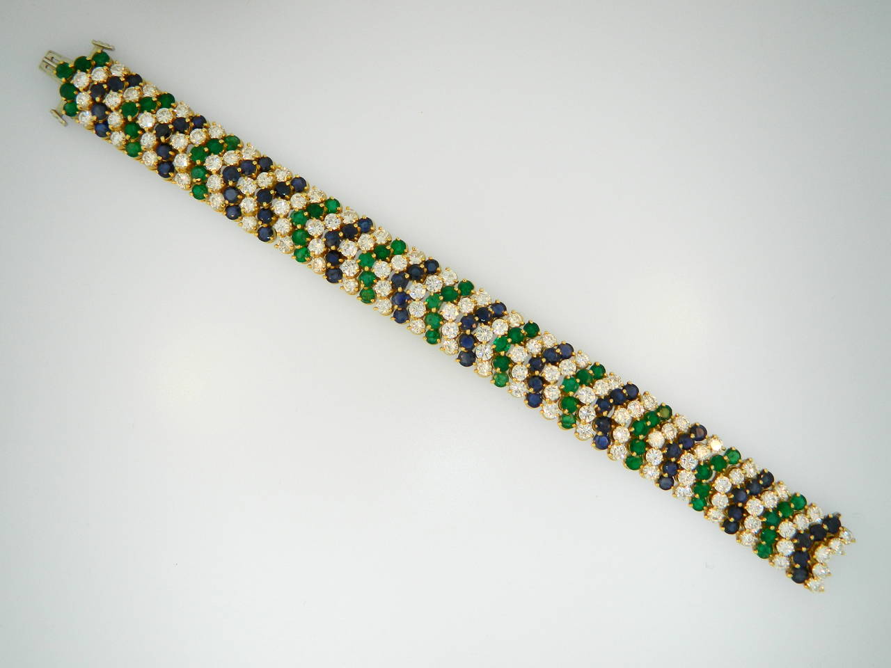 A 1960s 18kt yellow gold, diamond, emerald and sapphire bracelet containing over 13+ carats of fine round brilliant cut diamonds, 5+ Carats of emeralds and 5+ carats of sapphires.  Beautifully made!