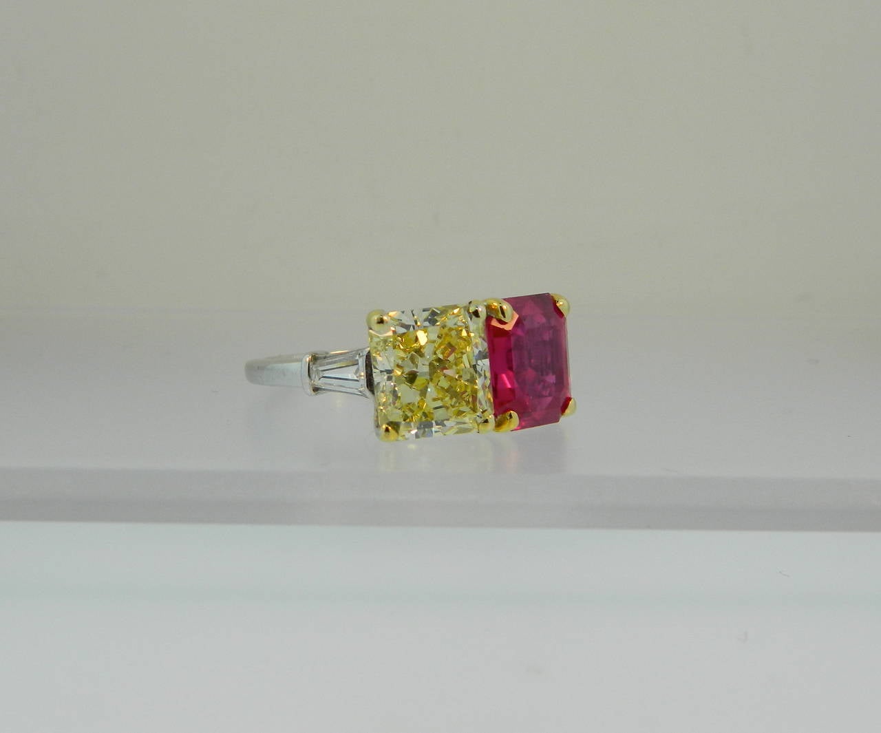 A stunning Platinum, SSEF certed, 3.75ct unheated octagonal step cut Burma ruby and GIA certed 3.26ct natural fancy yellow radiant cut diamond twin ring by Bulgari.