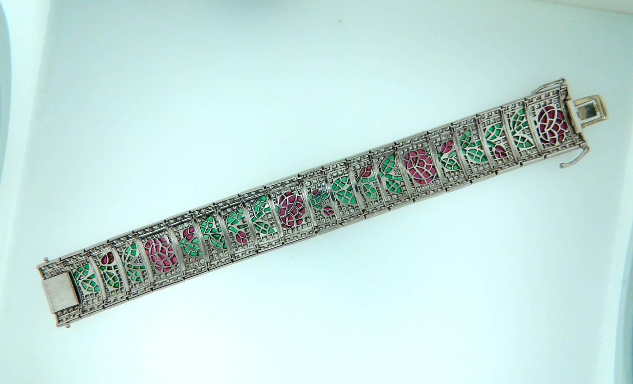 A beautifully made platinum, diamond, ruby and emerald rose bud/flower motif bracelet.  Circa 1990.  Marked PT900 5.80cttw Rubies, 5.75cttw Emeralds and 8.36cttw of fine diamonds.