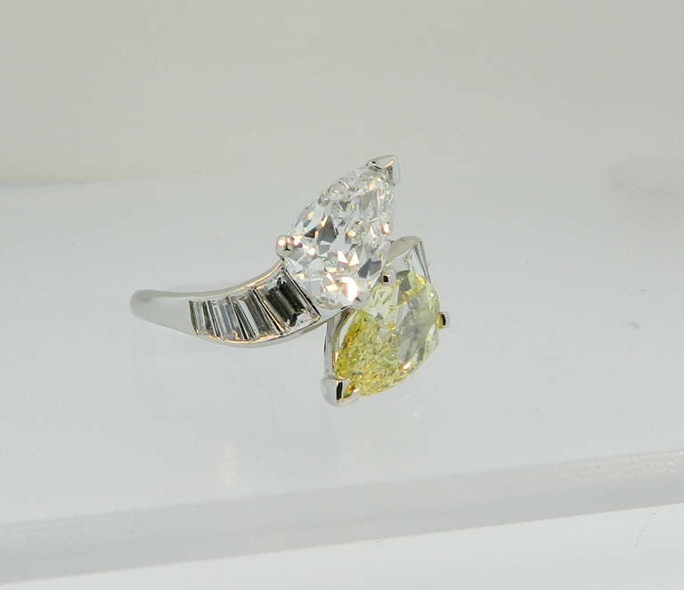 A wonderful 1930s Diamond and Platinum bypass ring featuring a GIA certified 1.95ct E VS2 Pear Shape, and a GIA certified 1.29ct Natural Fancy Yellow VS2 pear shape.  These two wonderful pear brilliant diamonds are mounted in Platinum and accented
