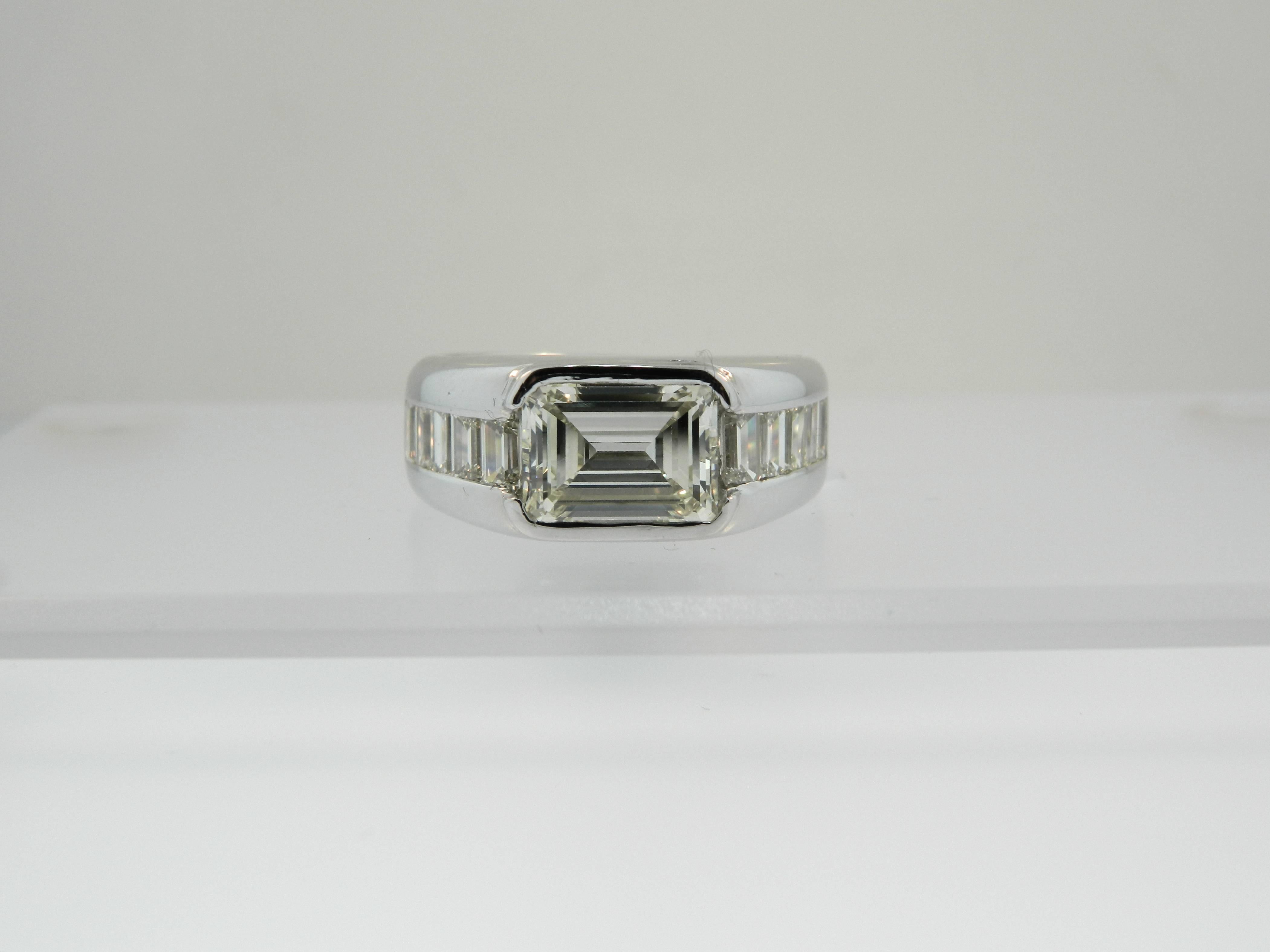 An impressive and large 3.73ct center emerald cut diamond (5ct+ Spread) and 18kt white gold men's ring by Hartz & Co.  3.73ct Emerald cut = M-N color/ VVS2 clarity. 