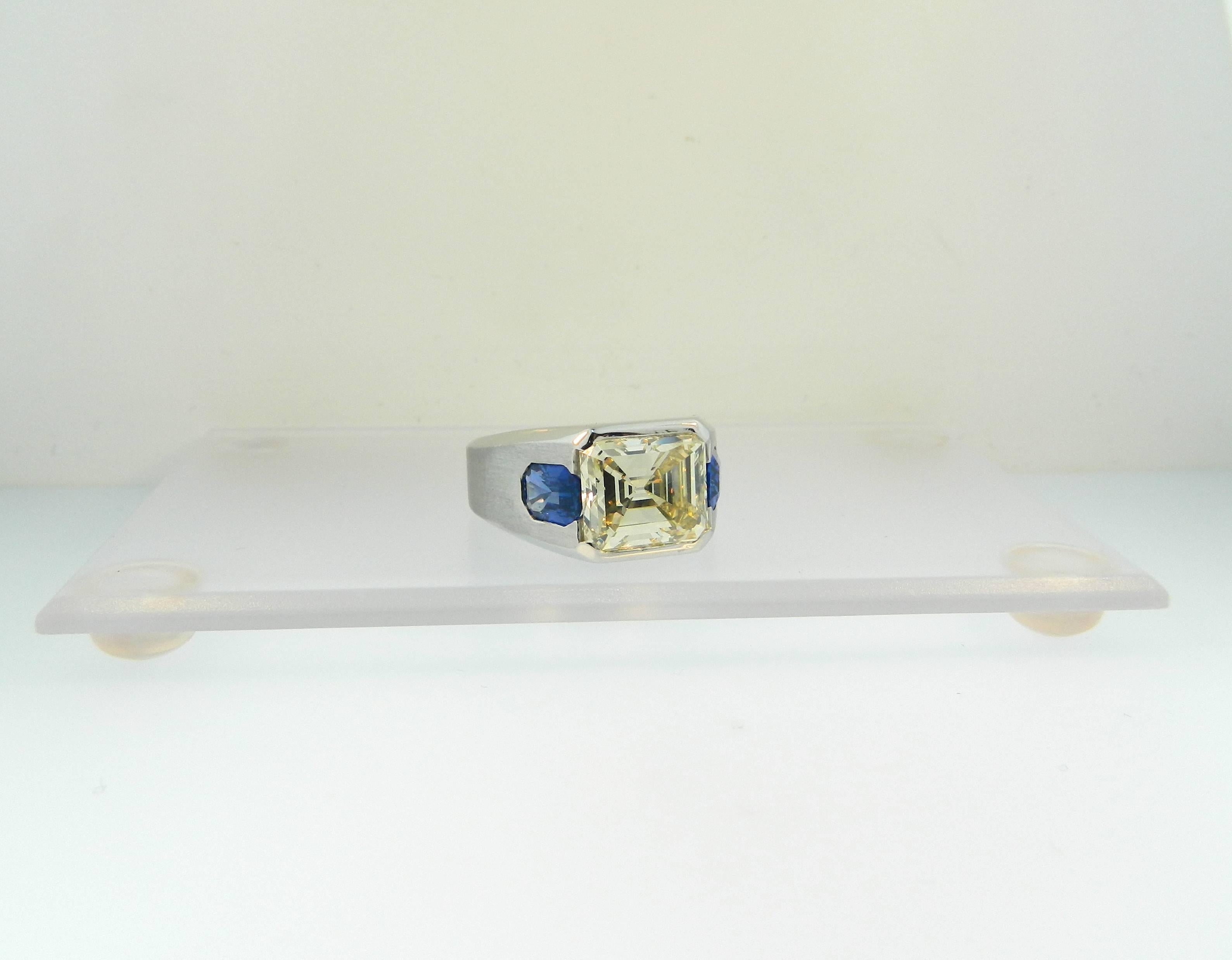 A fabulous and large platinum, emerald cut diamond and sapphire signet ring.  1 Emerald Cut Diamond=8.25ct W-X, VVS1.  2 Emerald Cut Sapphires=3.05ct total weight. 