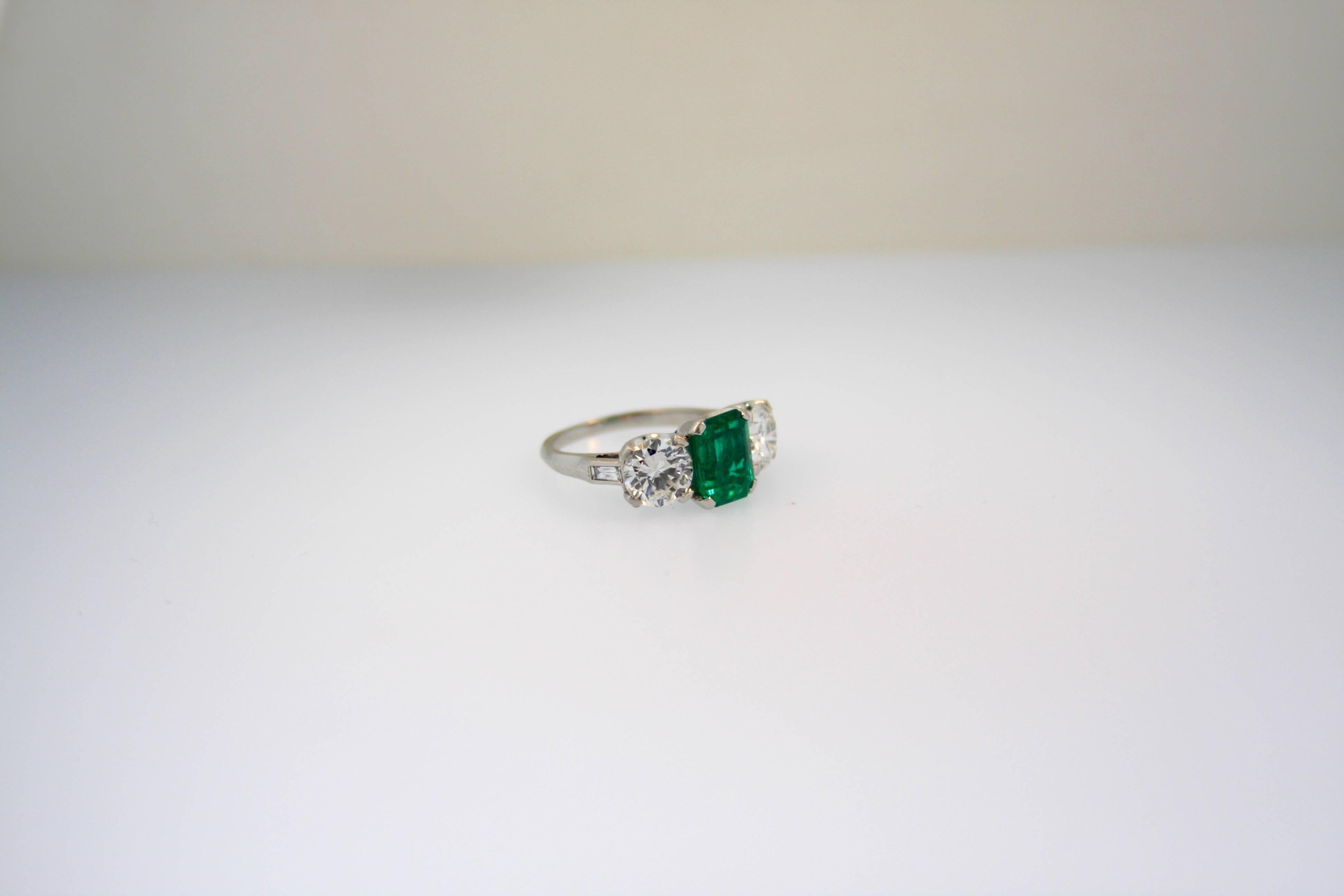 A superb 2.24ct AGL certified Colombia Minor Oil  Emerald Cut Emerald, GIA Certified 1.15ct H VS2 and 1.17ct H VS2 Transitional Round Brilliant cut diamond platinum ring.