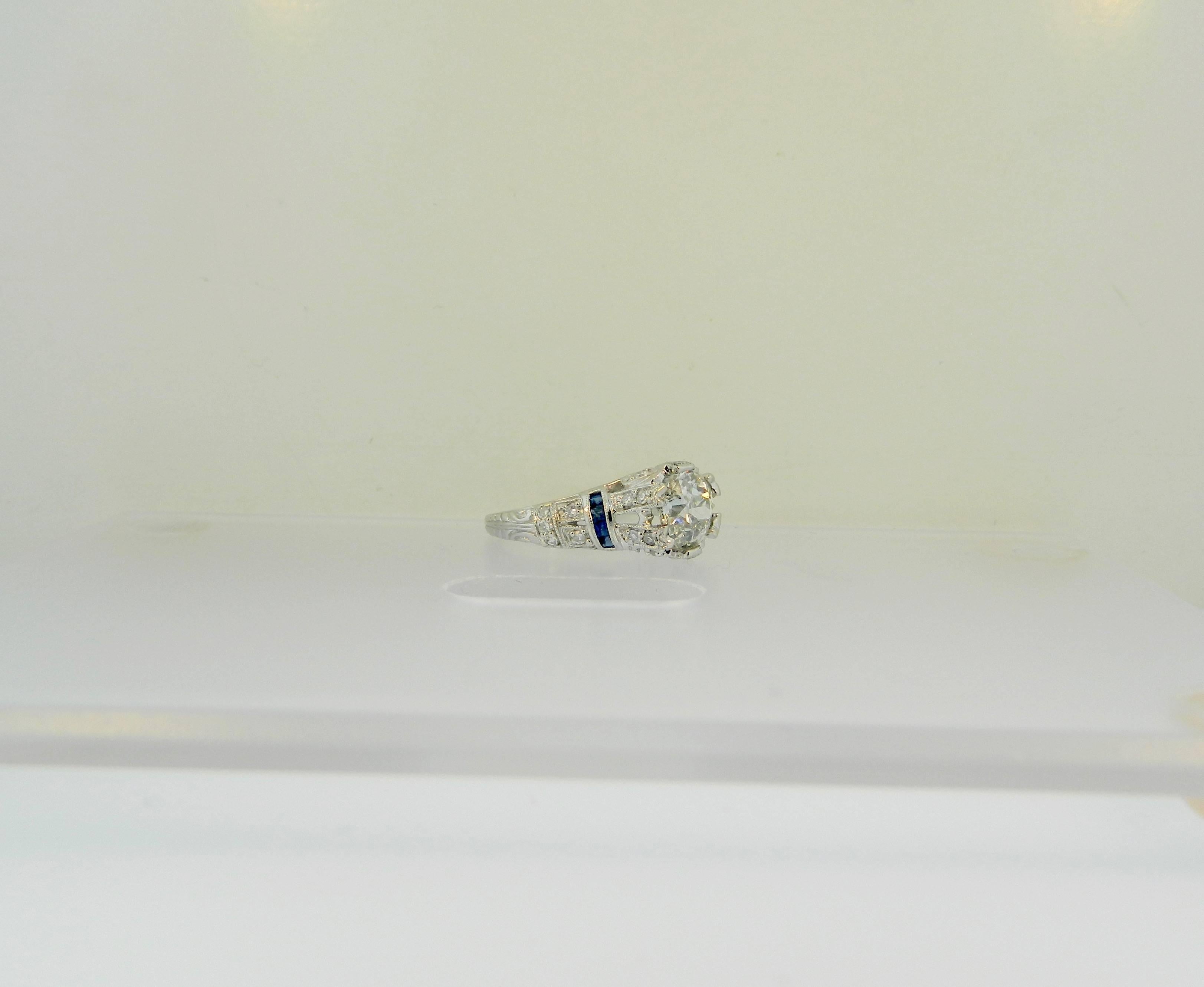 A wonderful Art Deco style, platinum, diamond and sapphire engagement ring.  The center diamond is a 1.38ct, I-J Color SI2 Clarity, antique Old Mine Cut diamond.