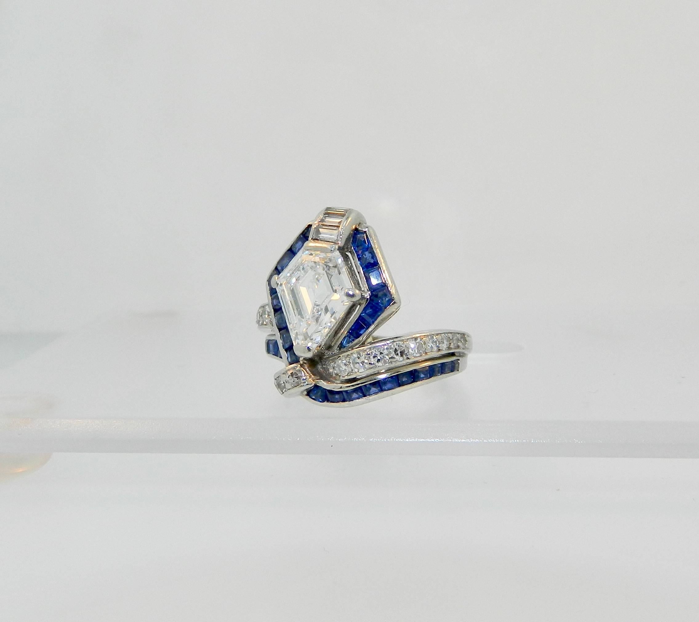 A stunning and rare Art Deco geometric Egyptian cobra diamond, sapphire and platinum ring.  Center kite shaped diamond=2.07ct GIA E VS1.