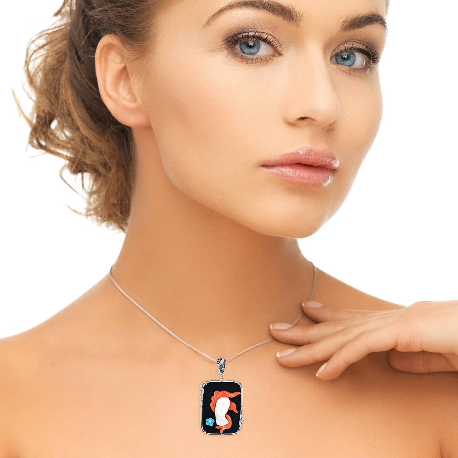 The beautiful cameo is artistically handcrafted in two layers on black onyx and on top the feminine face caved out of white coral and hair with red coral & the flower on the side by turquoise. This beautiful piece is bezeled with white gold frame