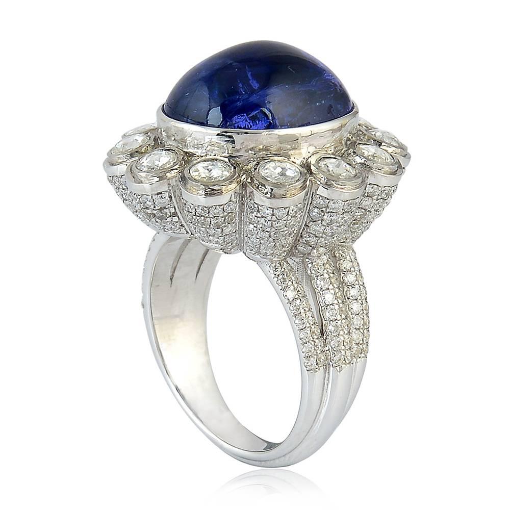 Tanzanite and Diamond Cocktail Ring in 18K White Gold set high with round diamonds set around making a flower is super sensational. On the sides white diamond pave work is done amazingly making the ring an owners pride and others