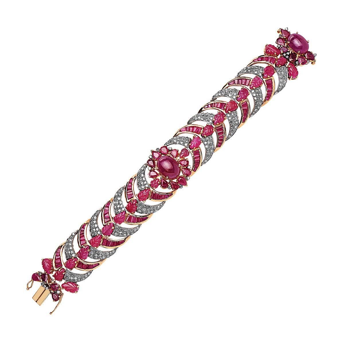 Alluring Diamond and Ruby bracelet in 18K white and yellow gold. This bracelet has carved ruby leaves, oval cabachon and baguettes with pave diamonds.  
Closure: Tongue clasps

18k: 55.65g
Diamond: 4.64ct
Ruby: 31.52cts
