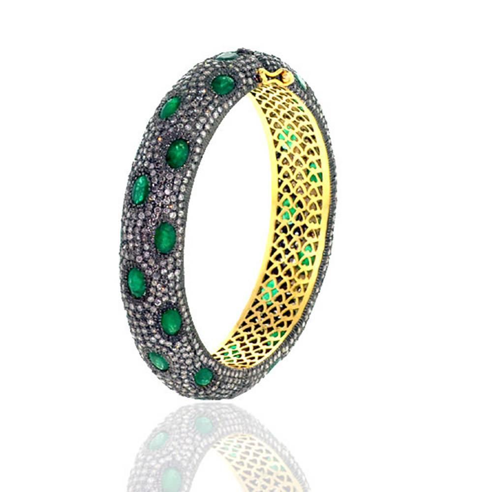 Vintage looking very attractive pave diamond and Emerald Bangle. This bangle is oval in shape and is openable with safety locks on both the sides. This has beautiful gold filigree work inside the