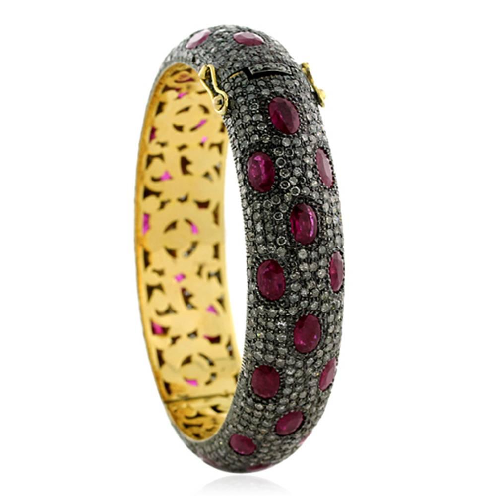 Vintage looking very attractive pave diamond and Ruby Bangle. This bangle is oval in shape and is openable with safety locks on both the sides. This has beautiful gold filigree work inside the