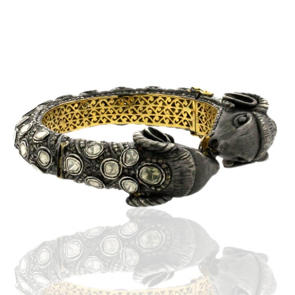 This bold and beautiful sheep face bangle showing calmness and love is a statement bangle to own.. This bangle has polki diamonds with pave diamonds around. This opens up on side and has safety clasps on side. 

14k:13.41g
Diamond: