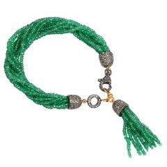 Bracciale con nappe di smeraldi e diamanti realizzato in oro e argento 18 carati