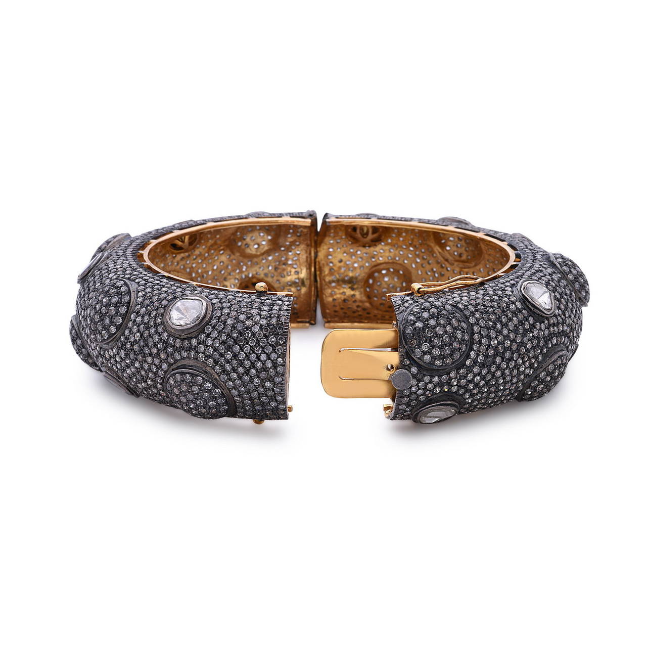 This stunning pave domed bangle is one of the best we have made of its kind, surrounded by a ring of rose cut diamonds. It sits comfortably around the wrist as it is openable with 2 clasps, totaling to 32.95 cts of diamonds set on silver and 14K