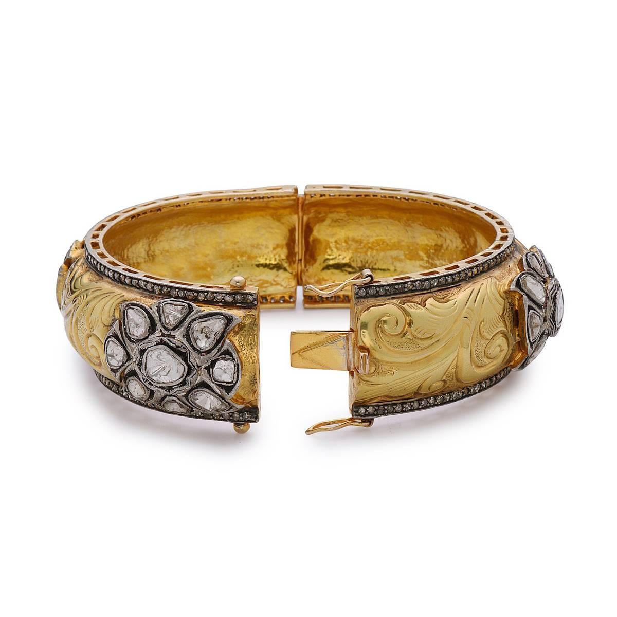 Adorn yourself with this super royal looking 14K yellow gold bangle with rose cut diamonds. This bangle is openable and has 2 safety clasps. Fits very well. The handcrafted embossed work all over the bangle with floral diamond motifs is absolutely