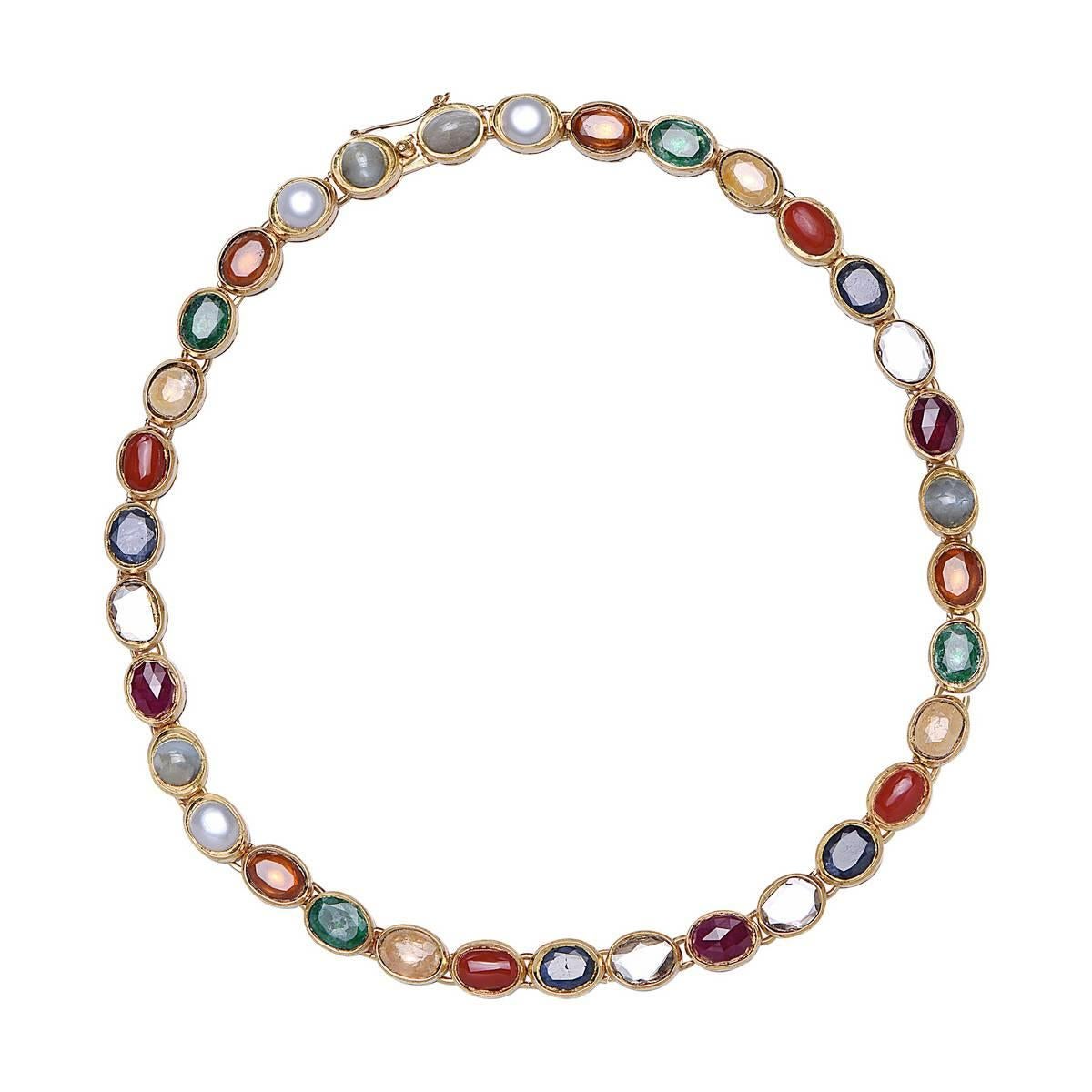 Add this 18K Yellow Gold Necklace with Navaratna Stones to your new year collection to get all the good luck and charm your way. It is open-able with a clasp. It is set with the stones mentioned below.

1. Ruby for Surya (Sun),
2. Pearl for