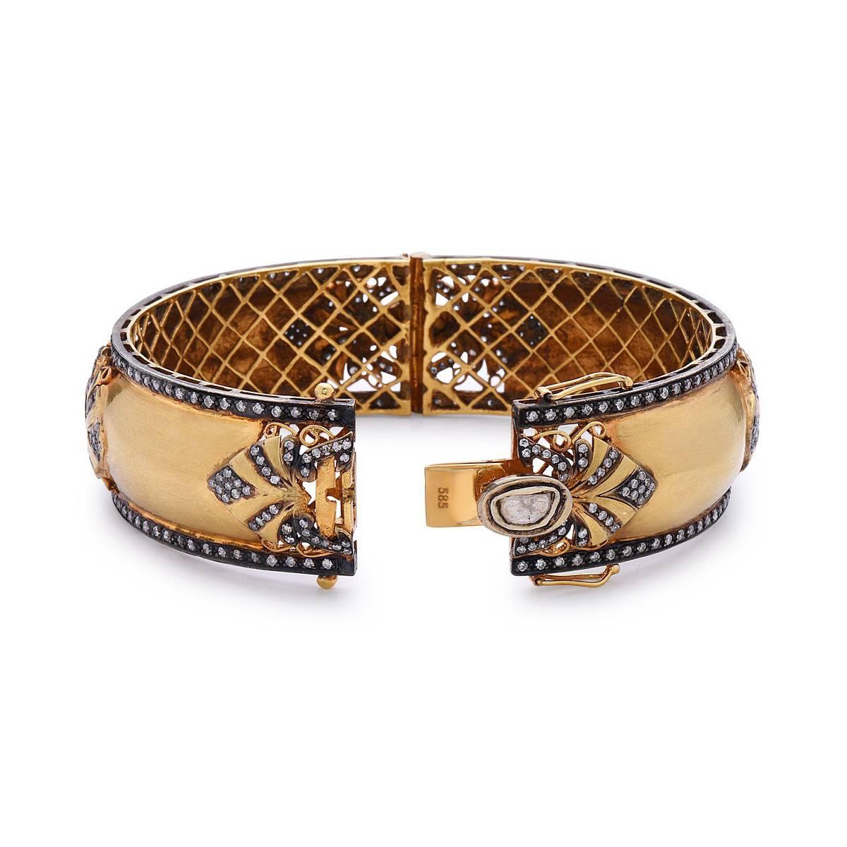 This stunning Gold Bangle with Diamonds has  a beautiful fan motif studded with diamonds on top. This is openable and round in shape with a check grill inside.  

14k:29.4gD:4.22ct                                                                   