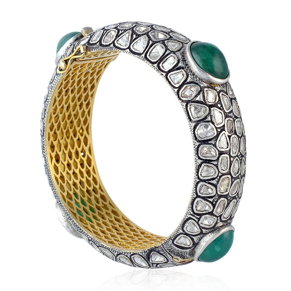 Gorgeous and very royal looking Emerald and Rosecut Diamond Bangle will be an asset to your collection. This bangle open up on sides and has a very safe locking system.

 14kt:29gms
Diamond: 18.25cts
Sl:44.13gms
Emerald:30.1cts
