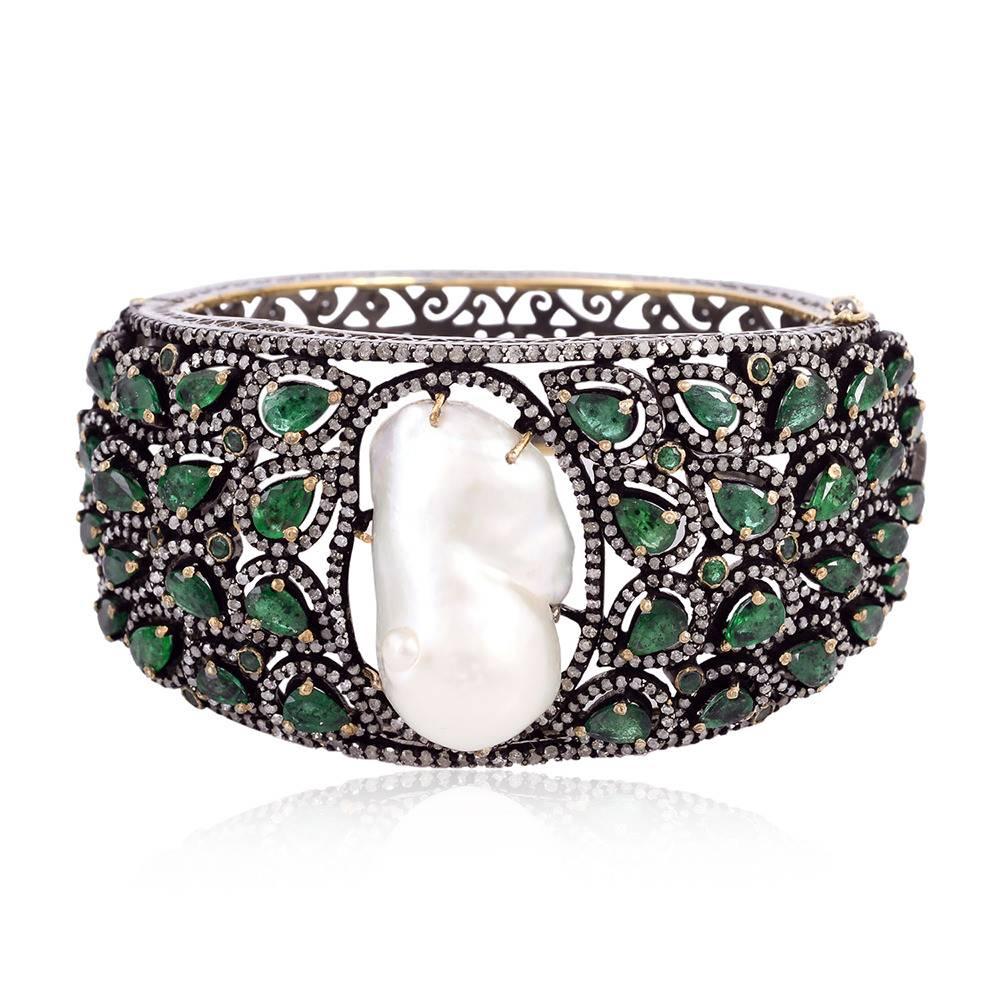 Beautiful Broad Pearl and Emerald Bangle with Diamonds which tapers down on the back side. 

18kt:6.3gms
Diamond:6.63cts
Slv:47.74gms
EMERALD 35.32ct