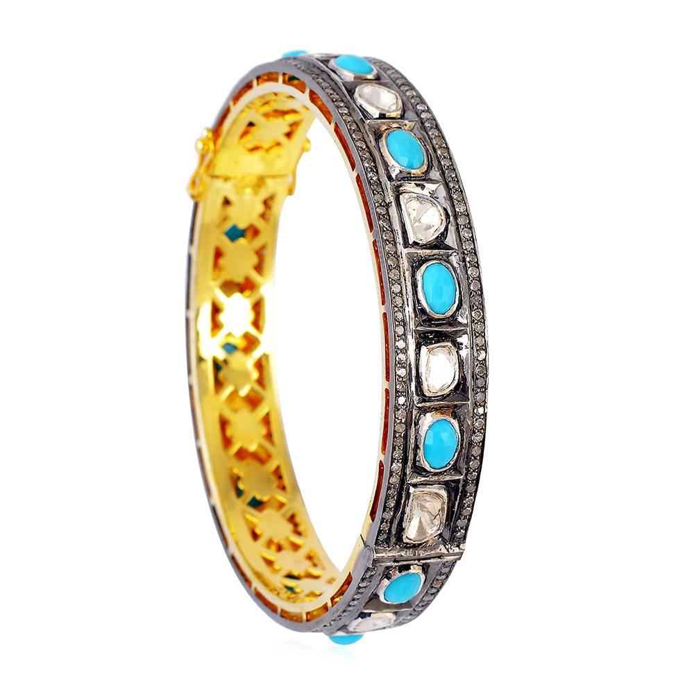 This pretty Rosecut Diamond and Turquoise alternating bangle is a very charming looking piece. This bangle opens up on side and has safety clasps on sides.

18k:1.80g
Diamond: 5.73Ct
Silver: 24.76g
Turquoise:4.70Ct