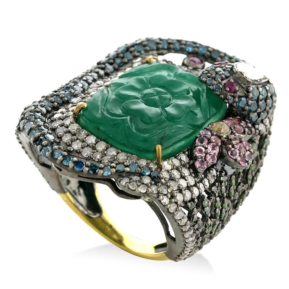 Pretty and trending this carved Emerald in center with blue diamond snake around and pretty floral motifs around this is a true cocktail ring

Ring Size: 7 ( can be sized )

18k:1.78g
Diamond:
