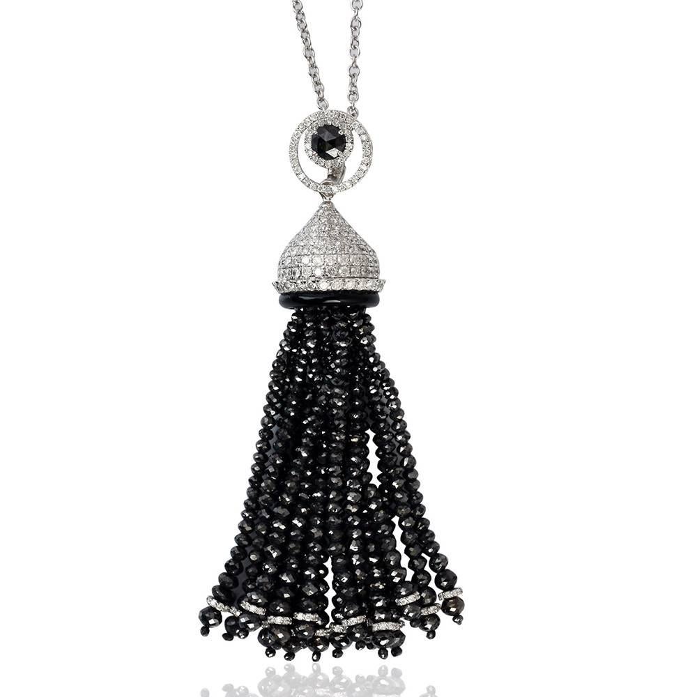 Ce long et élégant collier à pompon en diamants noirs et blancs en or blanc 18 carats est une pièce mystique à parer. Il est doté d'un fermoir à l'arrière pour une fermeture en chaîne. Nous avons également des boucles d'oreilles assorties.
 