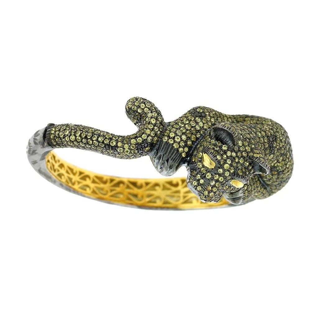 Lovely antique looking Diamond and Yellow Sapphire Panther Bangle in 14K gold and silver. This bangle is oval in size, opens on side and locks very firmly.

14k: 10.4g
Diamond: 1.39ct
Yellow Sapphire: 12.13cts