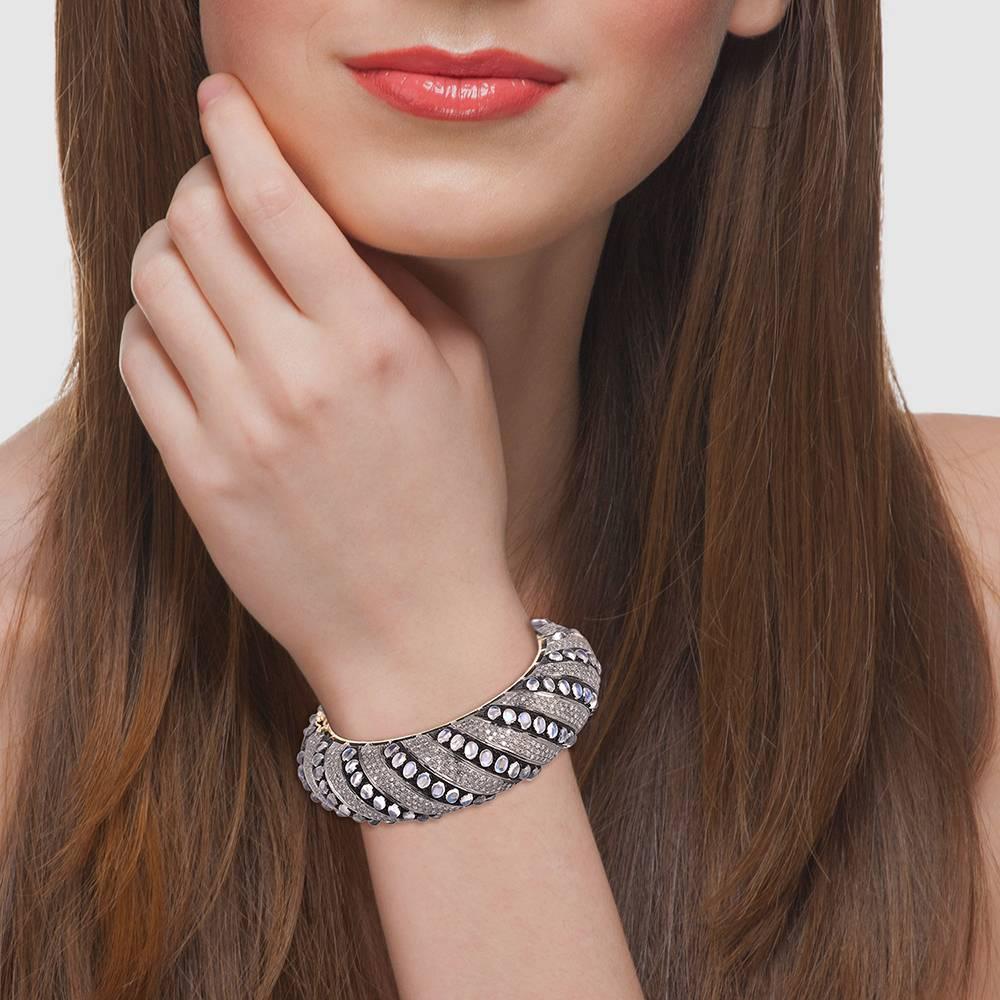 Questo audace e bellissimo braccialetto con pietra di luna e diamanti di forma ovale è un braccialetto dell'eternità. Questo braccialetto si apre lateralmente con una chiusura di sicurezza.

14kt:10.94gms
Diamante: 9,92cts
Slv:65.25gms
Pietra di