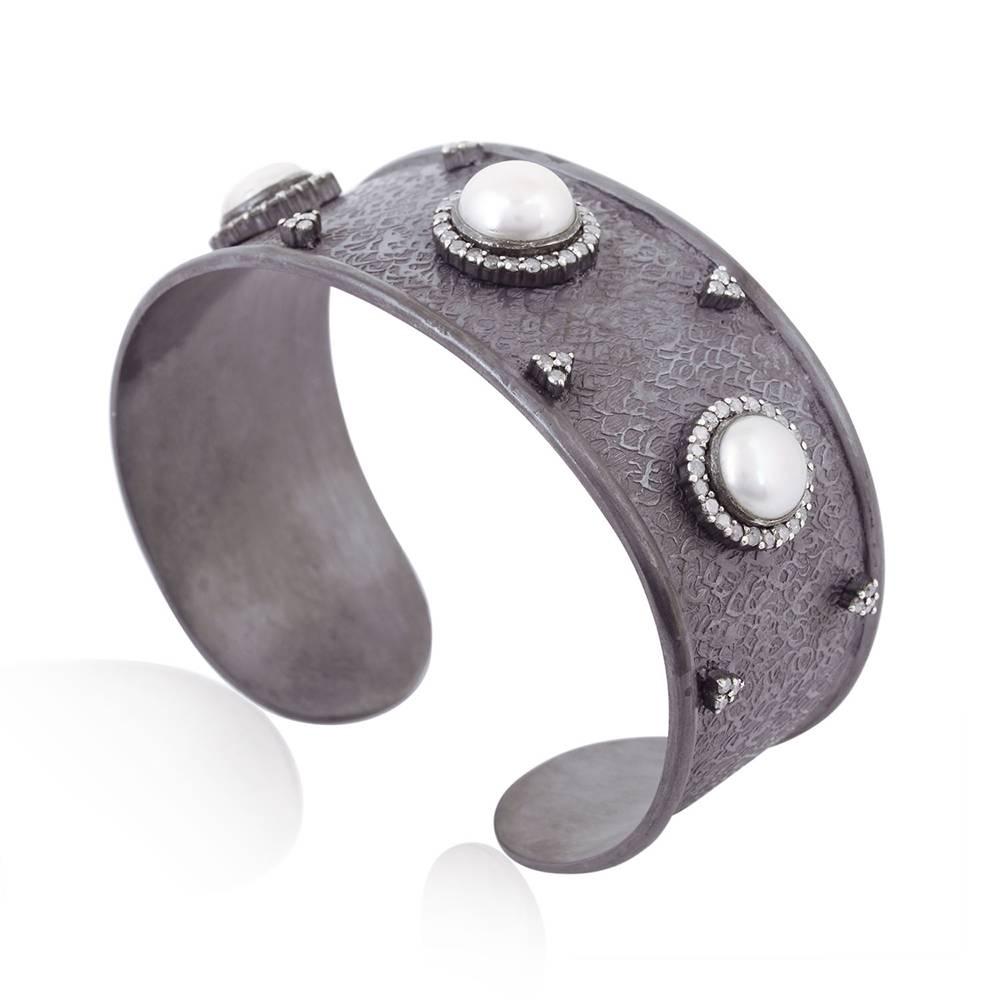 Complete your Boho look with this Dark Black Rhodium Cuff with Diamonds and Pearls. This cuff is open on the back and slides on easily.

Diamond: 1.6Cts
Slv: 39.29gms
PEARL: 11.88Cts