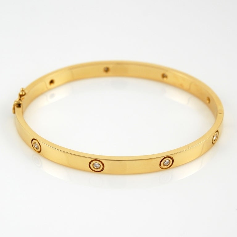 Italian 18kt yellow gold bangle bracelet featuring aproximately 0.90carat of diamonds.