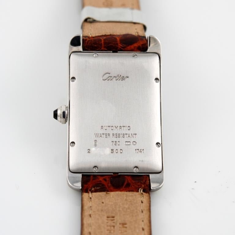 18k white gold Cartier Tank Americaine wristwatch, Ref.1741.
White dial with Roman numerals, date aperture at 6 o'clock. 
Automatic movement. Faceted sapphire-set crown. 
Leather strap with 18k white gold Cartier  buckle. 
The watch comes with