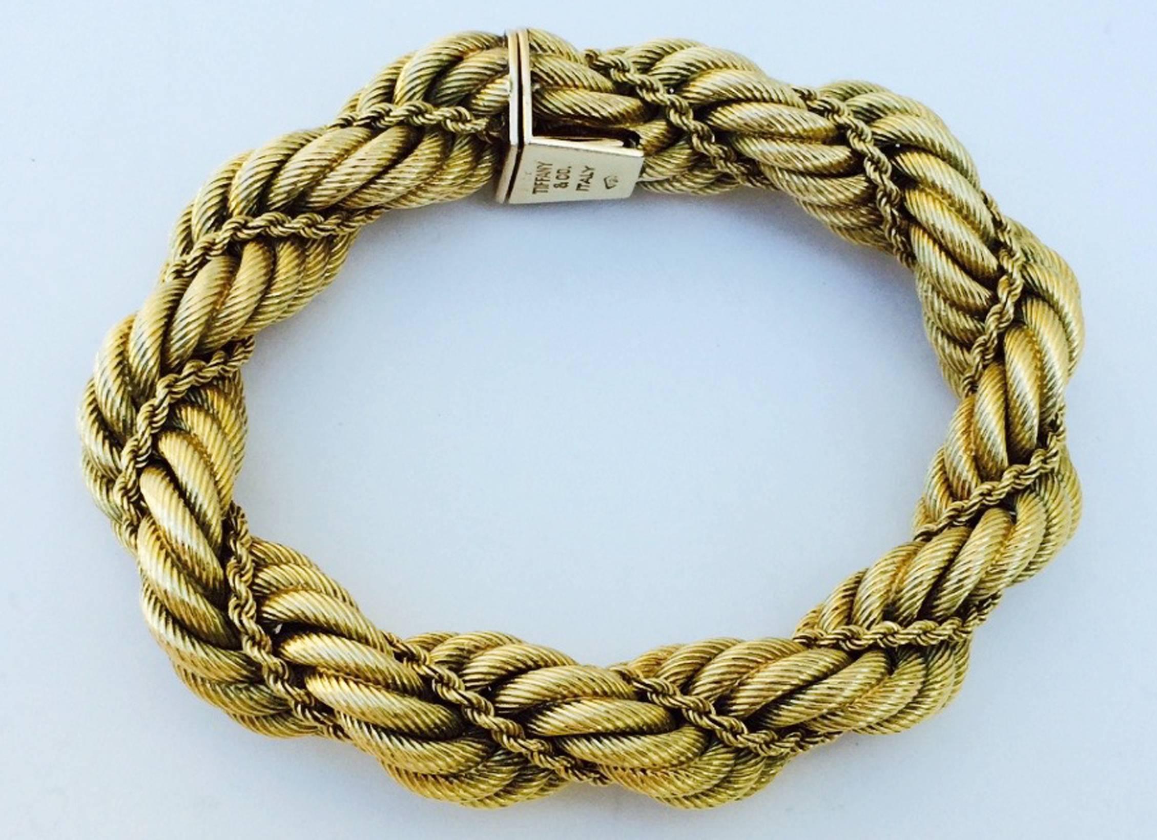 A fine Tiffany & Co. heavy gold rope bracelet. Signed yellow gold item twisted with two chain styles. Item secures with a hidden push clasp closure and hinged lock. Excellent with no issues.