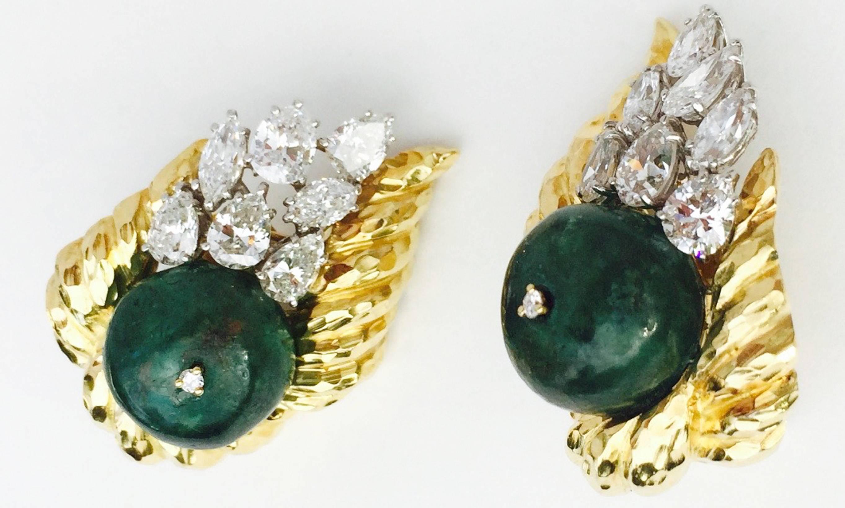 A exquisite pair David Webb emerald and diamond ear clips. Large signed hammered yellow gold items feature 15mm cabochon emerald bead centers (approx. 20ct. each) sprinkled with sparkling pear and marquise diamonds (approx. 10ctw). Outstanding