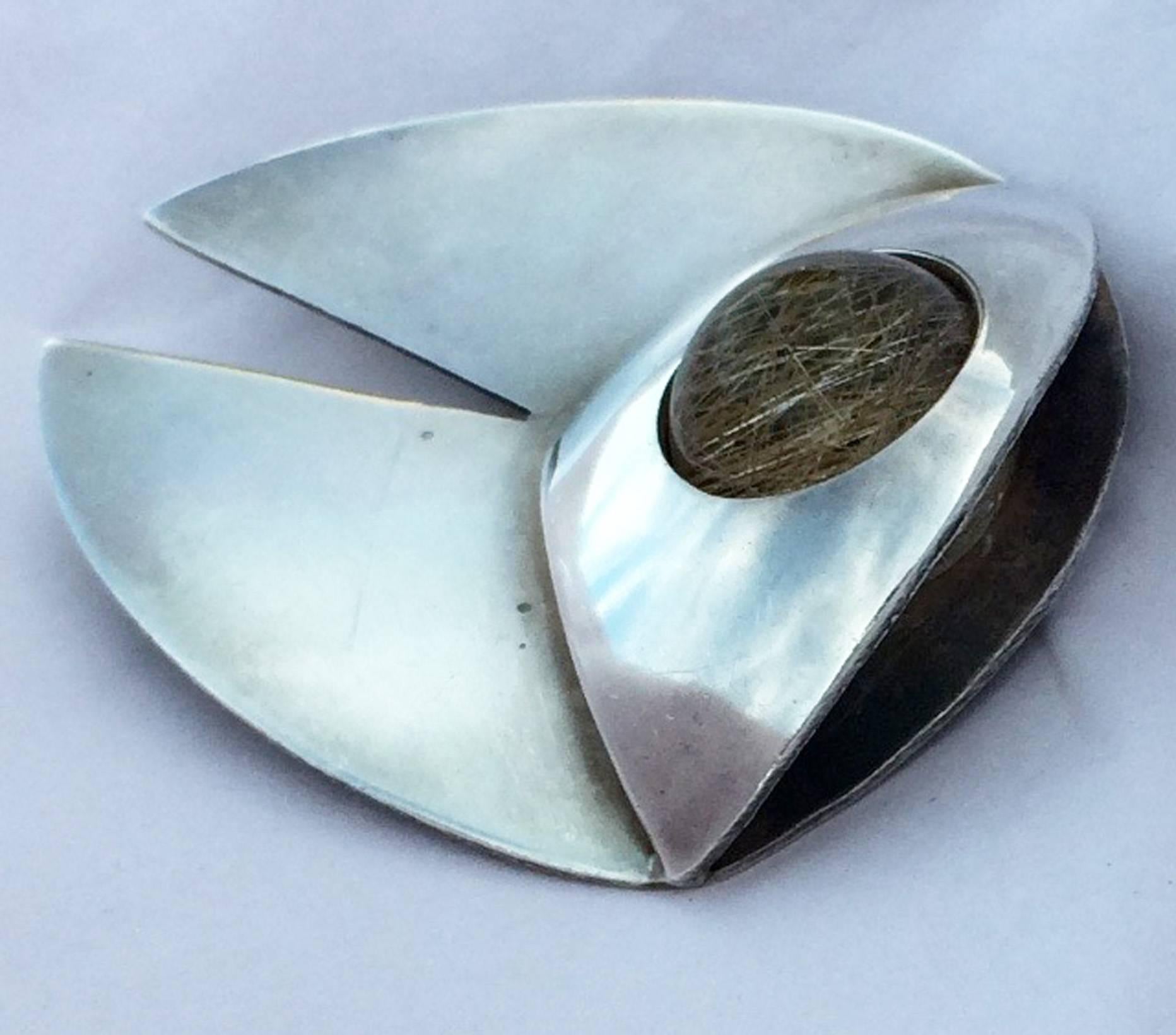 A fine and rare Art Smith modernist sterling brooch. Signed item features a polished round rutilated quartz stone. Original pin back intact. Outstanding three dimensional design and execution.