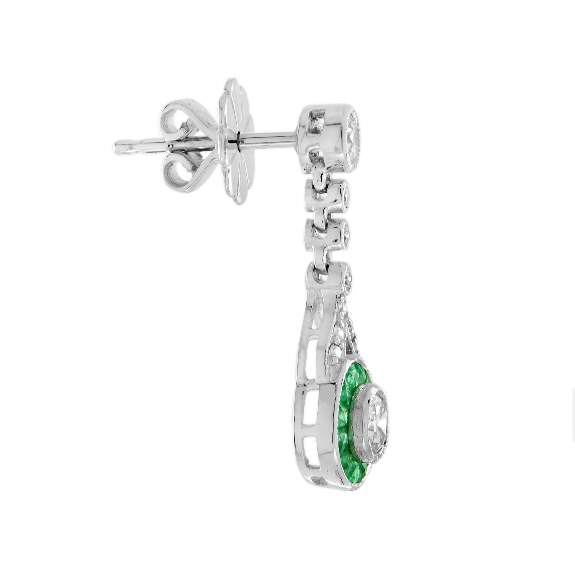 Un bellissimo paio di orecchini in oro bianco di ispirazione Art Deco. Sono incastonati con diamanti e smeraldi taglio francese. Il diamante centrale è di circa 0,17 carati per lato. L'attenzione ai dettagli e la lavorazione a grana fine