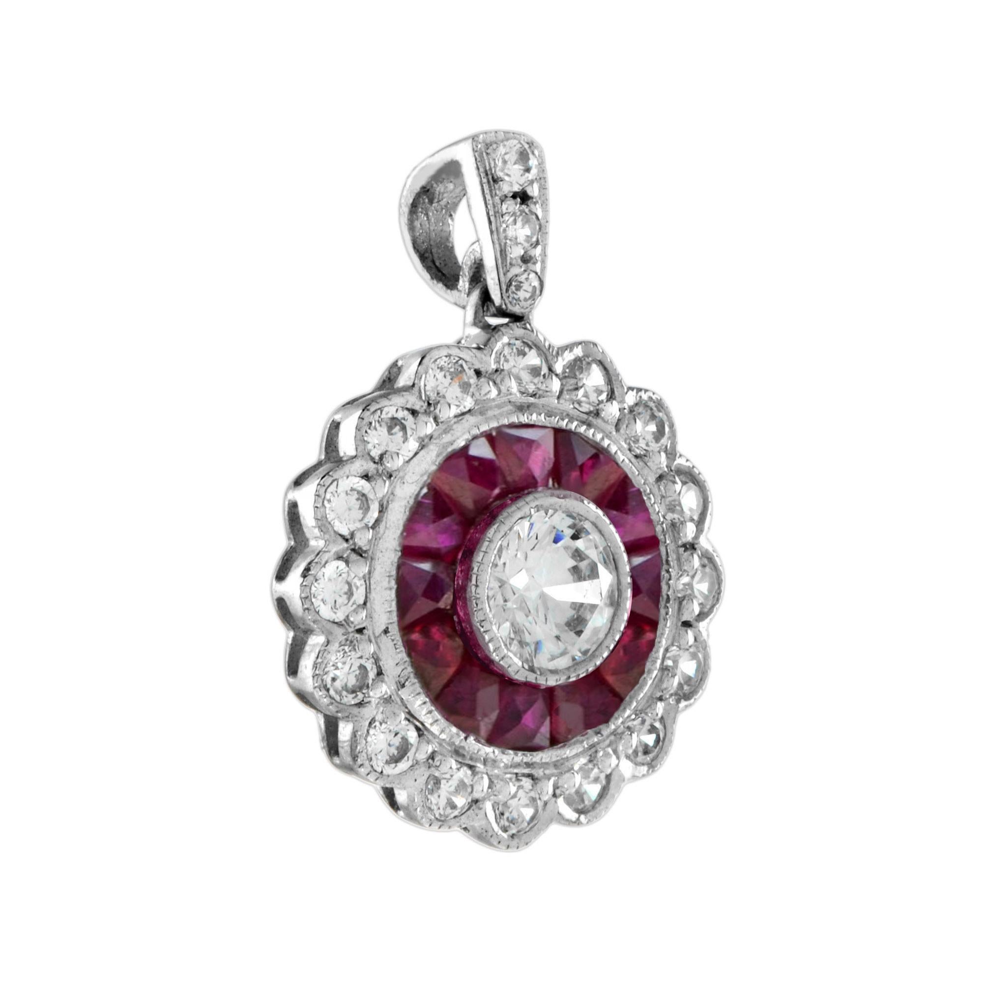 Une paire glamour de pendentifs cibles d'inspiration Art déco sertis d'un diamant rond de taille brillant au centre. Le diamant pèse environ 0,1 carat et est entouré de rubis de taille française et d'autres diamants sertis dans de l'or avec des