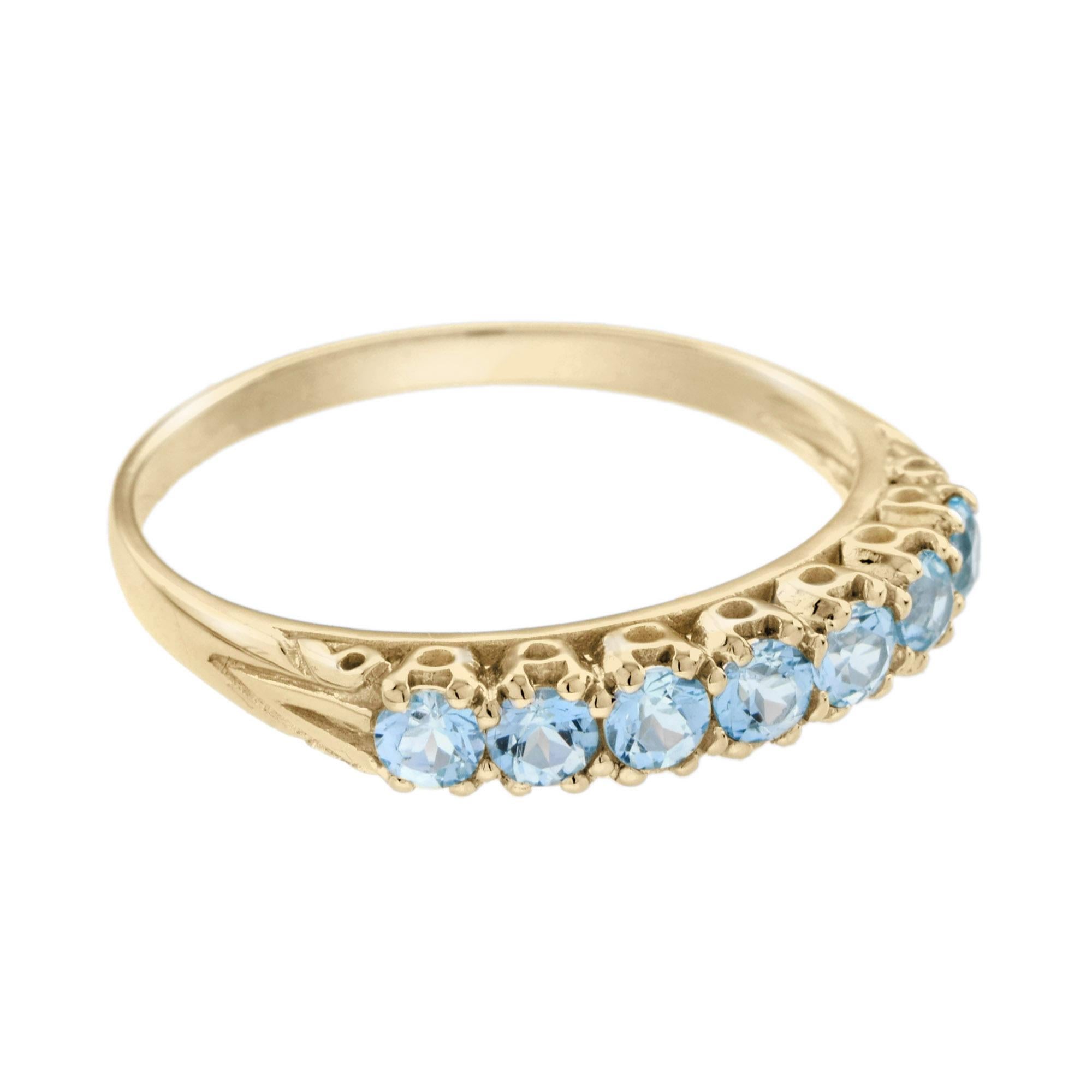 Bellissima fede in oro di ispirazione vintage. Incantevole incastonatura a rebbi, con sette topazi blu cielo brillanti e vivaci, peso totale di circa 1,4 carati. I dettagli a voluta completano questo splendido pezzo che può essere indossato da solo