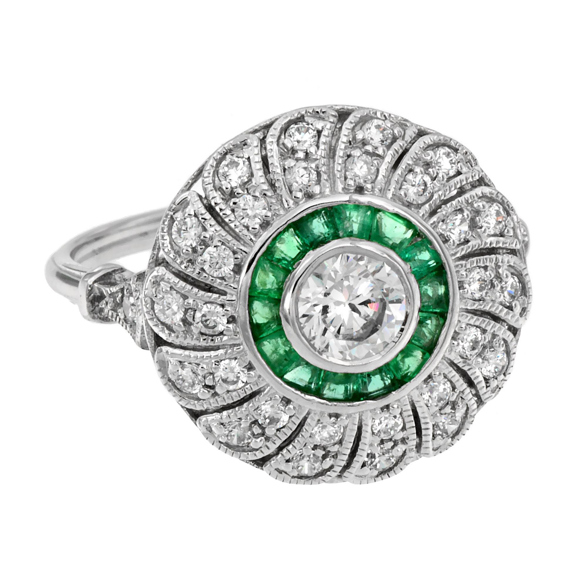 Questo anello con diamanti e smeraldi in stile Art Déco è assolutamente divino. È realizzato in oro e centrato con un diamante rotondo taglio brillante da 0,35 carati circondato da uno smeraldo taglio francese. L'alone esterno ha un totale di