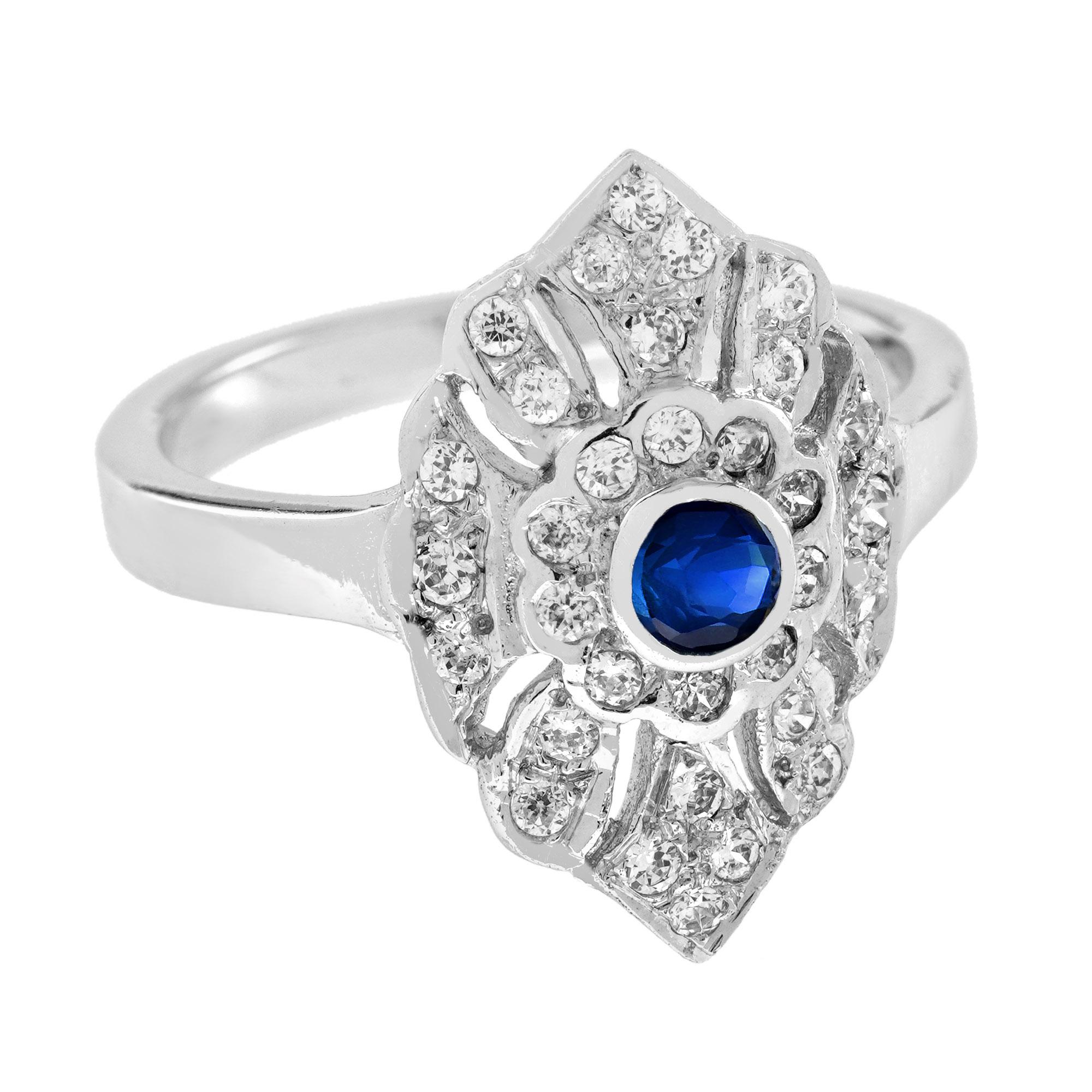 Cette bague exceptionnelle en saphir bleu et diamant présente un saphir bleu rond central serti dans un chaton en or blanc 14k et entouré d'un halo de 30 diamants ronds de taille moyenne, ramifiés entre les magnifiques détails ajourés et milgrainés,