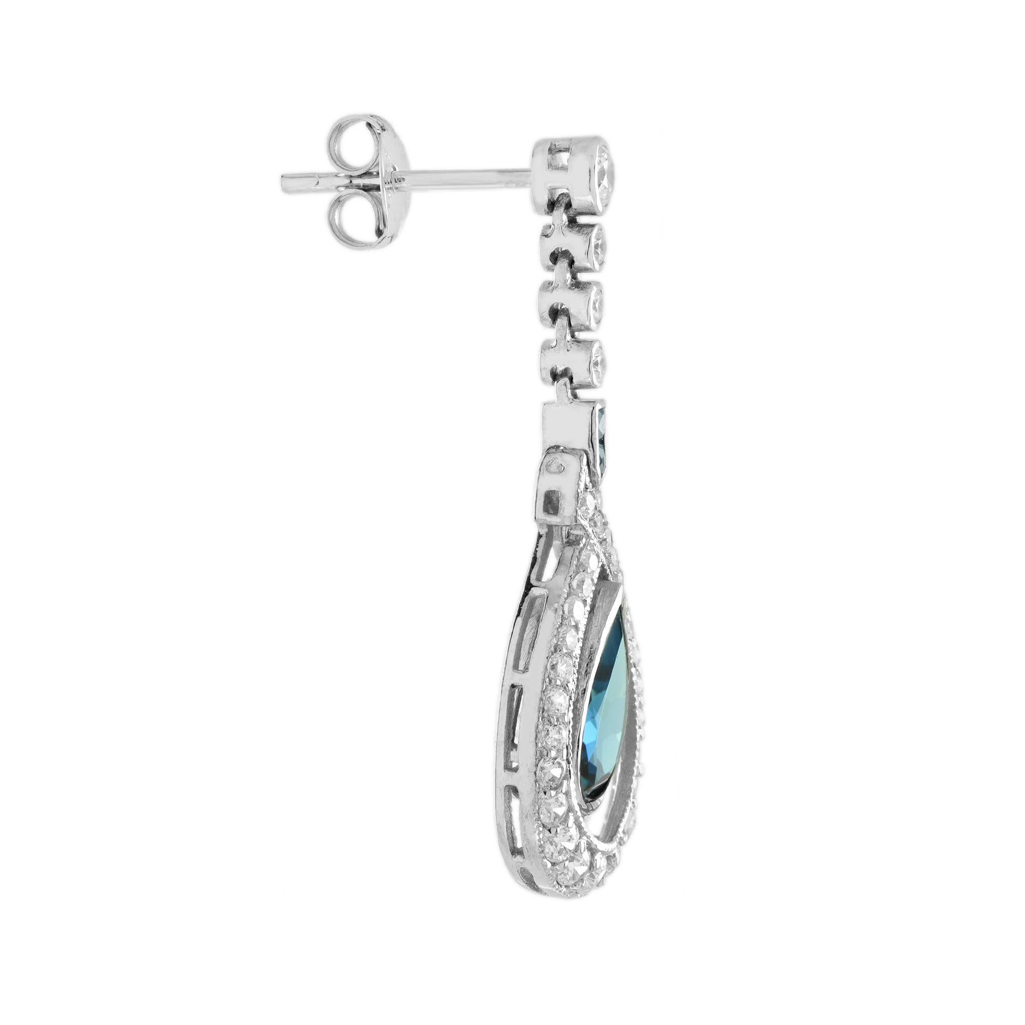 Ces magnifiques boucles d'oreilles classiques au design antique sont absolument captivantes. La couleur riche et uniforme de la topaze bleue de Londres en forme de poire, accentuée par les diamants, ferait un merveilleux cadeau pour un anniversaire