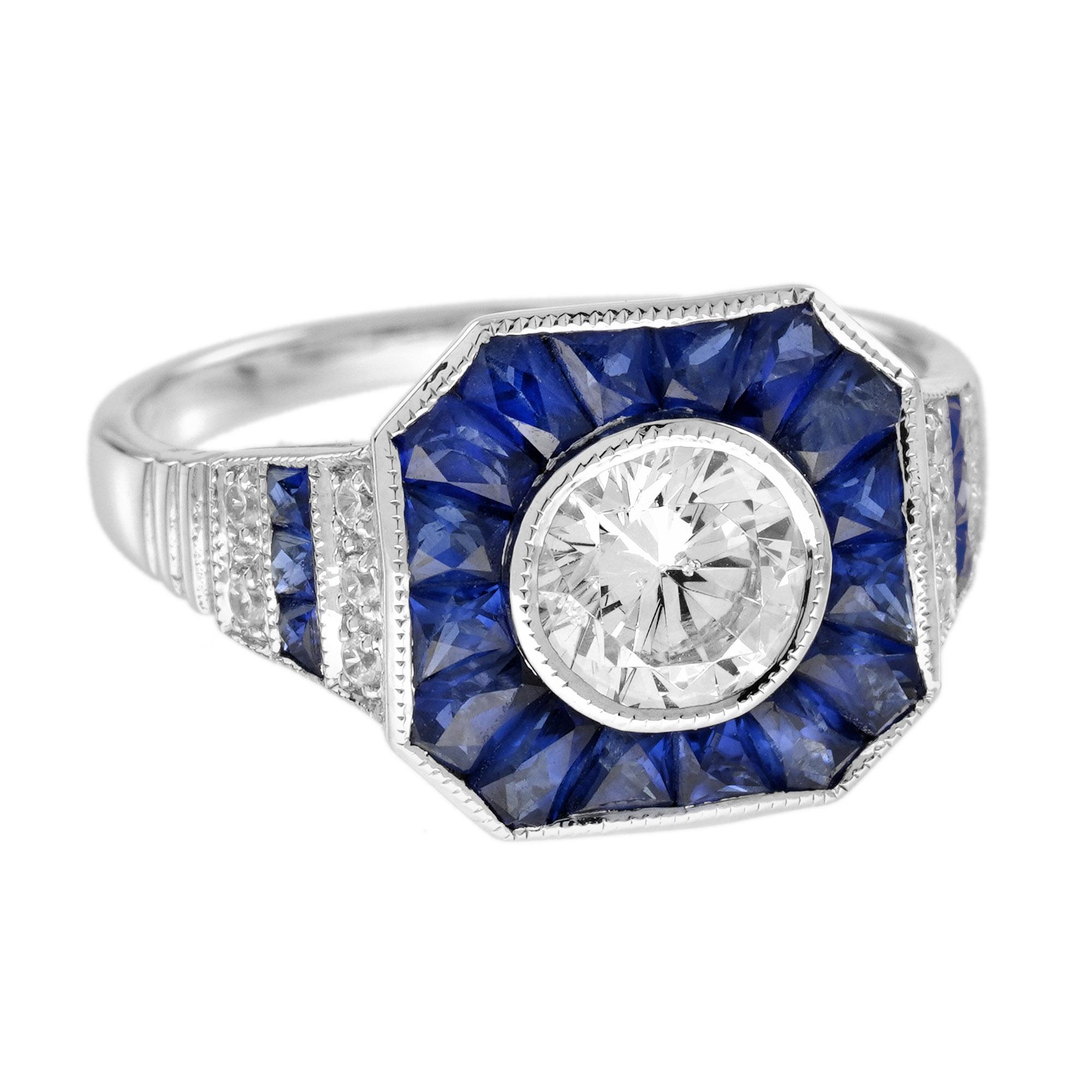 Cette remarquable bague en diamant bleu et saphir bleu présente un diamant rond central de 0,75 carat de taille brillant, serti dans un chaton et entouré d'un halo de saphir bleu de taille française avec des détails de milgrain, modelé en or blanc.