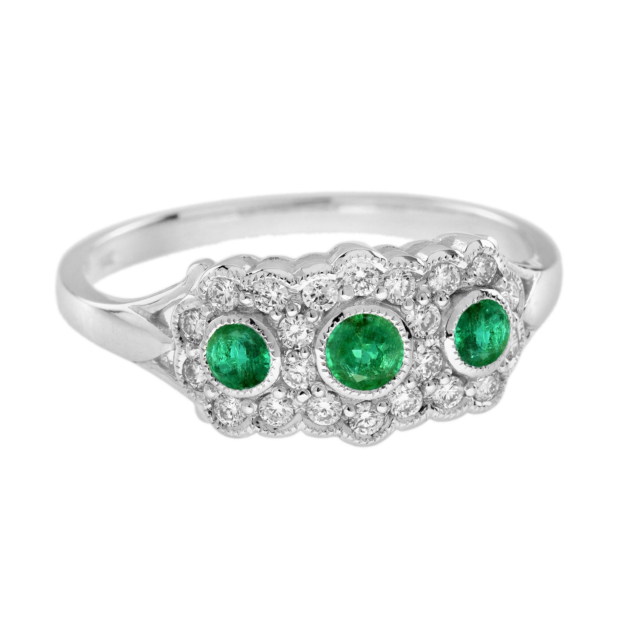 Un trio d'émeraudes rondes d'un poids total d'environ 0,49 carat se côtoient et jettent un éclat vert glorieux, entourées d'environ 0,34 carat de petits diamants ronds étincelants. Cette magnifique bague est ornée d'un milgraining détaillé et bordé