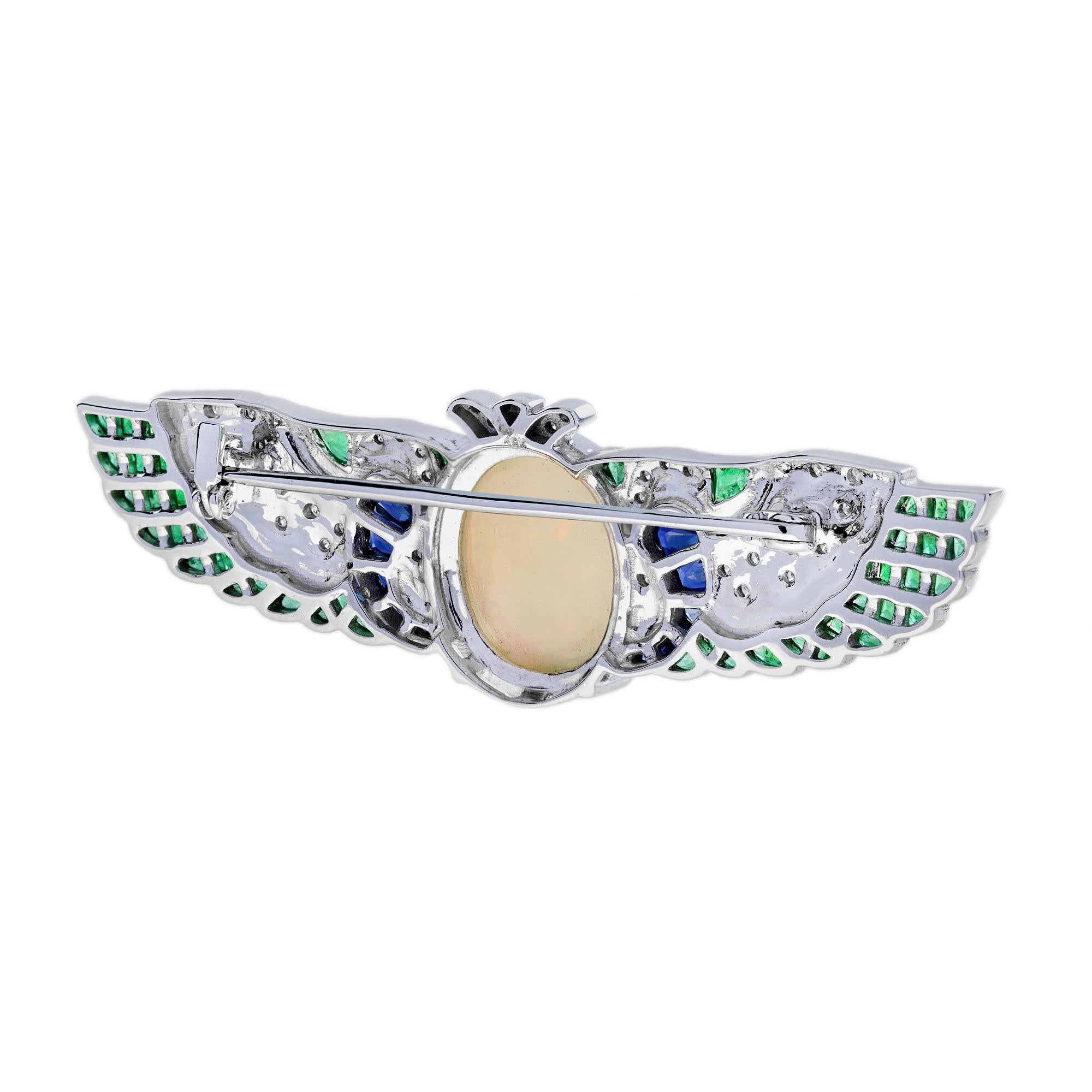 Un'eccezionale spilla in oro bianco di ispirazione Art Deco ben realizzata. Al centro un opale etiope di circa 4,51 carati con le ali su entrambi i lati. Ciascuna ala presenta un dettaglio a spirale ed è decorata con zaffiro blu taglio francese,