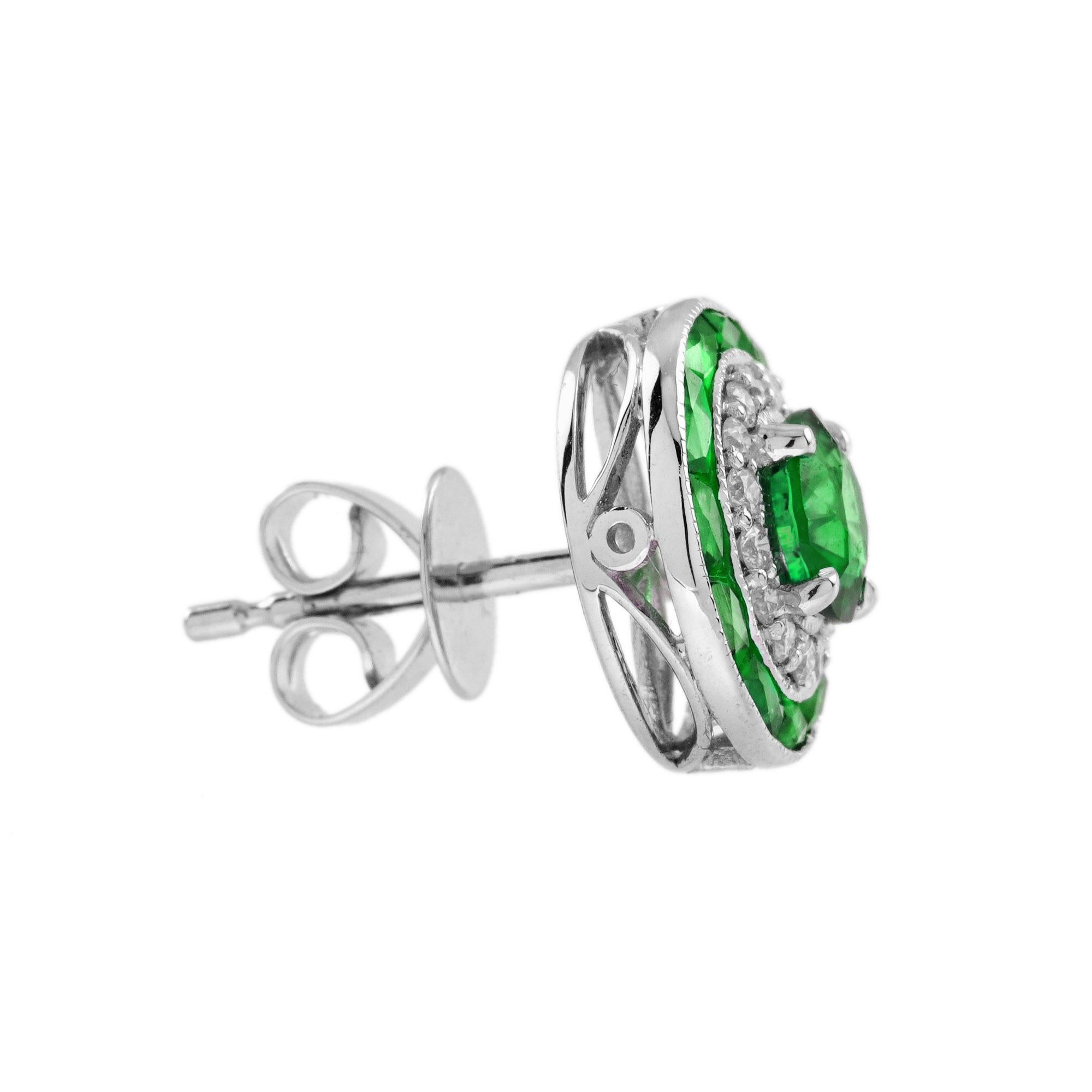 Polyvalentes et faciles à porter, ces boucles d'oreilles sont le choix idéal pour donner un coup d'éclat à vos lobes. L'émeraude centrale de 5 mm. pesant environ 1,00 carat (chacune) de ces boucles d'oreilles de style déco chic est entourée de