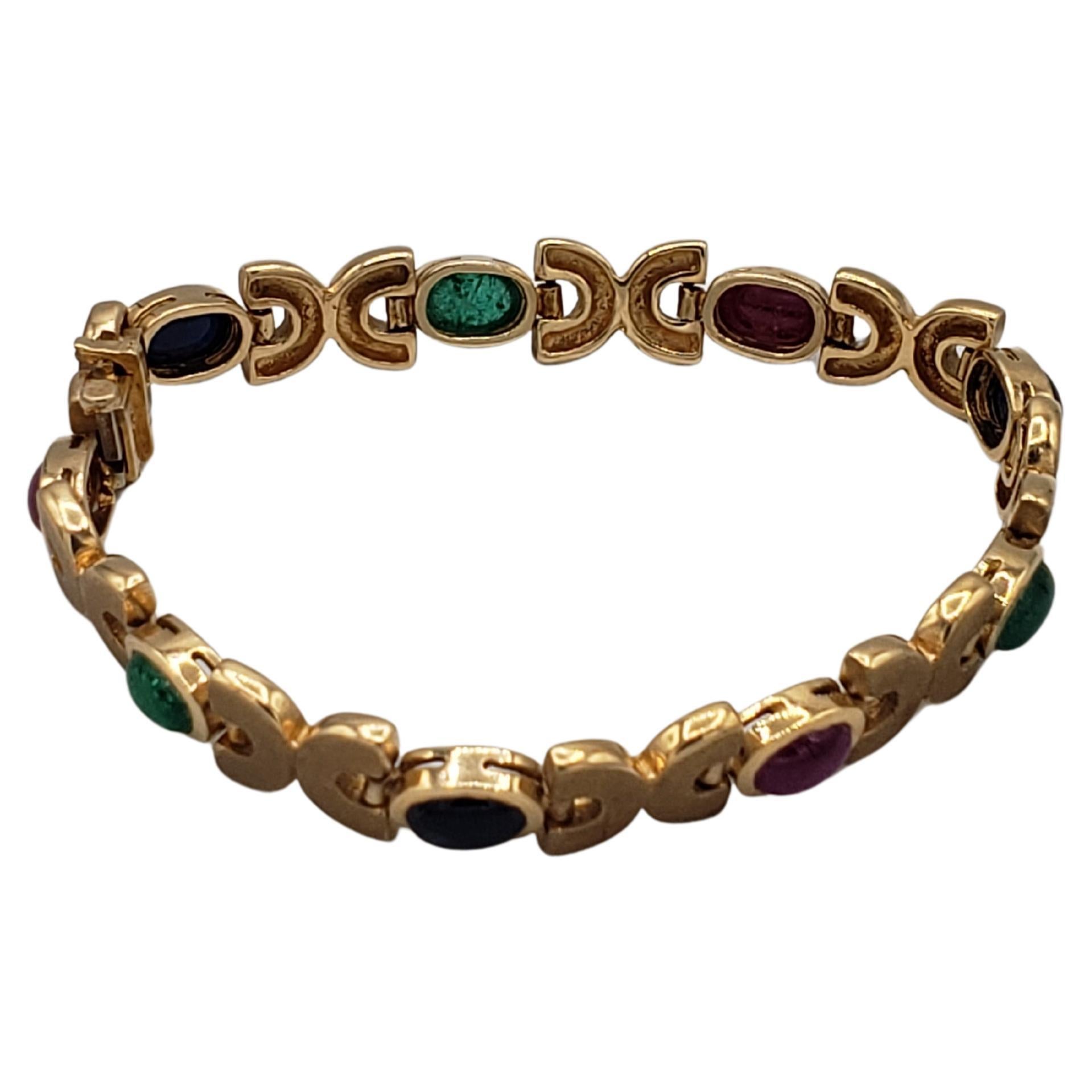 This gorgeous bracelet is a stunning example of beauty captured in precious gemstones. Crafted in 14k solid yellow gold, this piece features natural ruby, sapphire, and emerald stones in oval shapes. The tennis-style bracelet measures 7 inches in