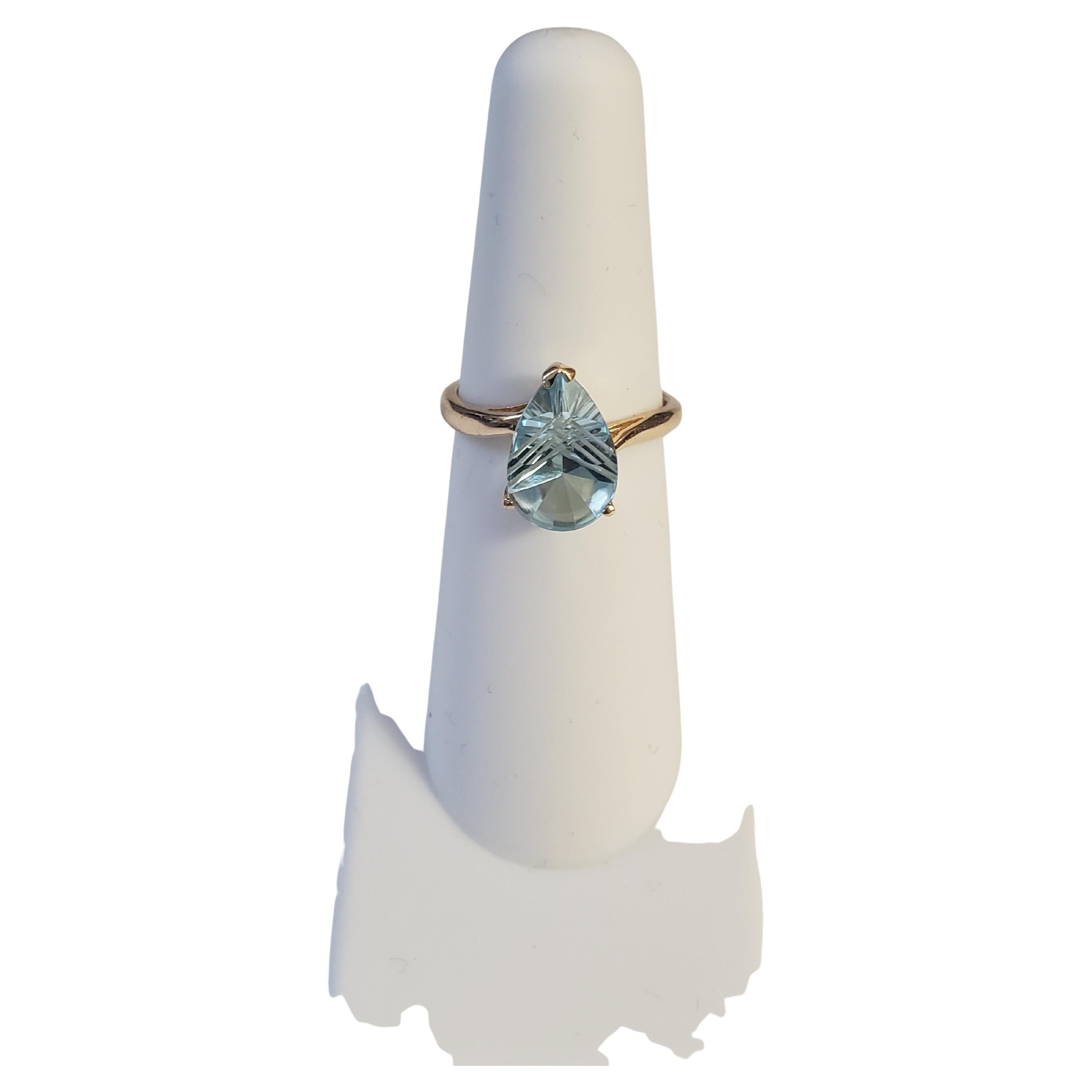 This beautiful ring from Fantasy features a special cut 3 Ct. natural sky blue topaz gemstone set in a 14K solid yellow gold band. The stunning pear-shaped stone is accented with a delicate crown design, giving it an antique and regal feel. This