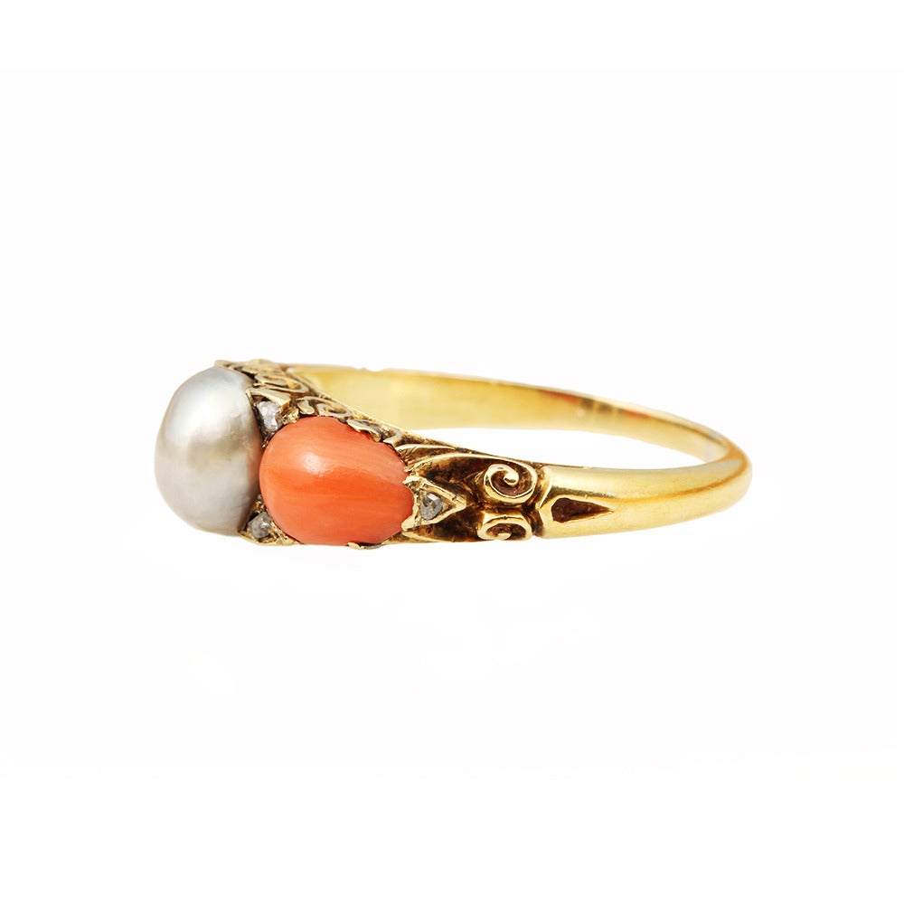Victorian coral and pearl ring set in 18k gold with natural pearl and rose cut diamonds. Circa 1880. English in origin.

Size 6.75 , can be sized.