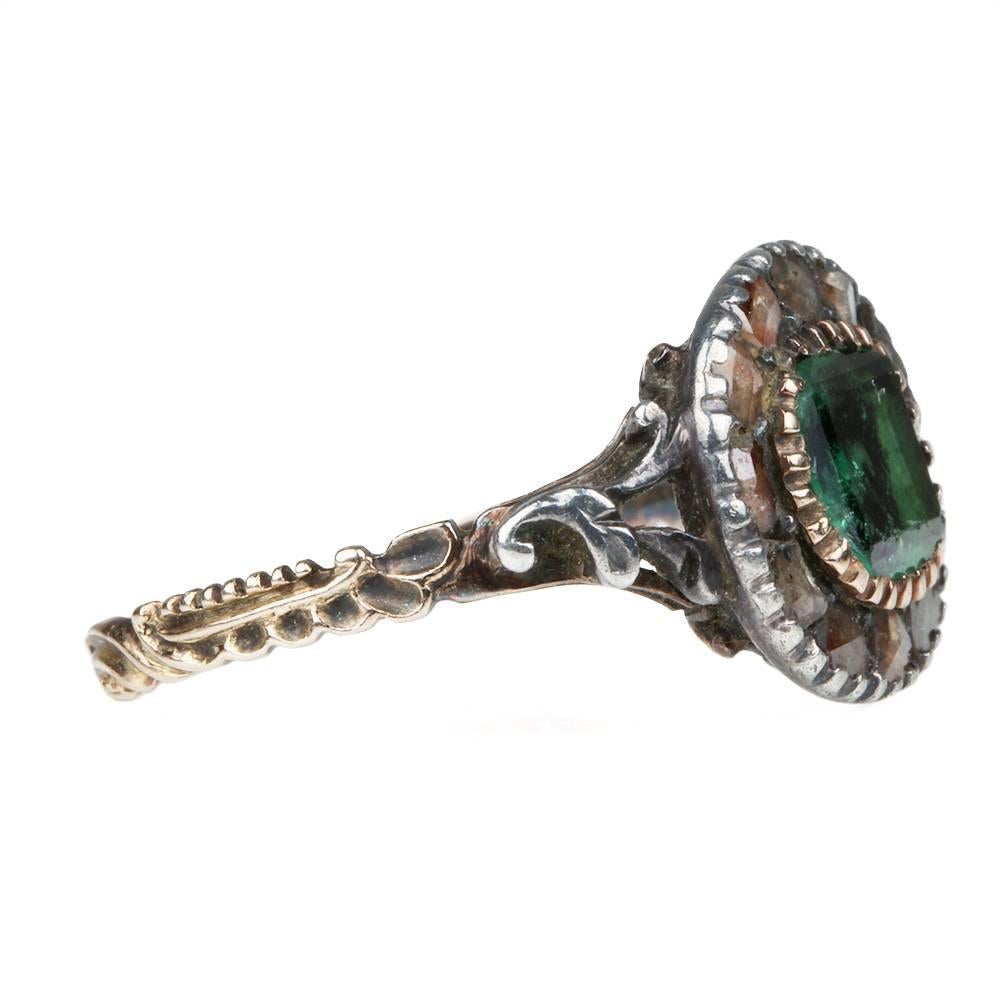Georgian era emerald & rose cut diamond ring. Gemstones are set in silver closed back foiled settings on a gold band. Circa 1800. Spanish in origin.

Size 9.25, can be resized but would loose detailing in the band. 