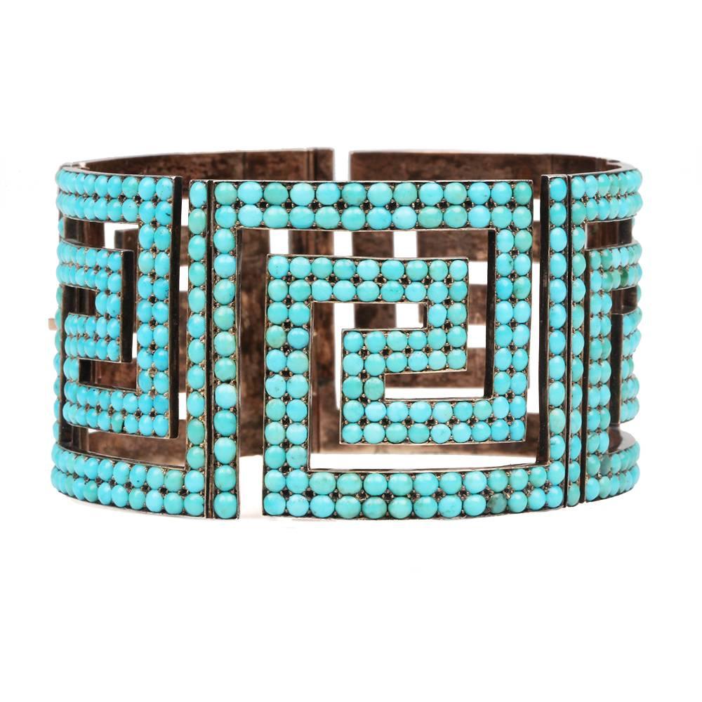 Victorian Era Persian Turquoise Bangle in Greek Key Pattern in Rose Gold. English in Origin. Circa 1880.

The bracelet is masterfully hinged at 5 separate points with a push button closure. at side with push button closure.  The bangle is .75"