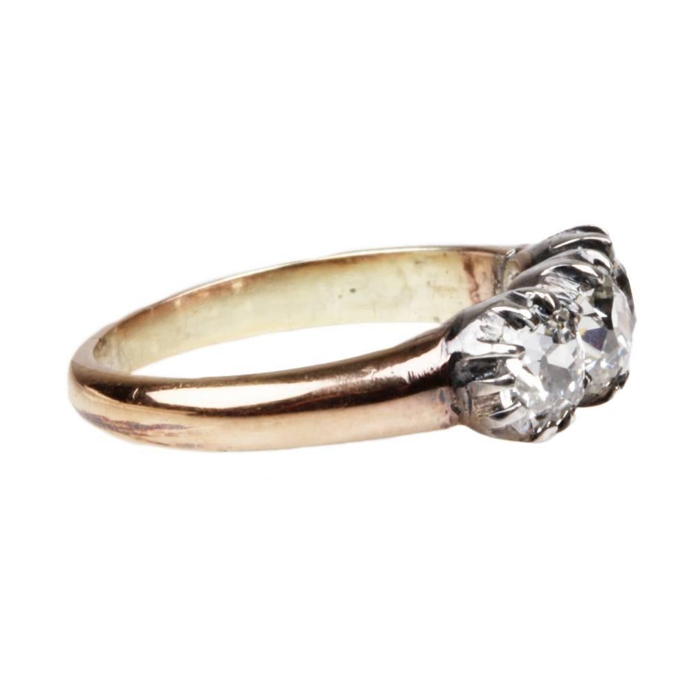 Mid Victorian three stone old mine cut diamond ring. Three bright stones weighing approximately 1.25 carats in total weight. The diamonds are set in silver on 18k gold. English in origin, Circa 1860. 

Size 5.25, can be resized