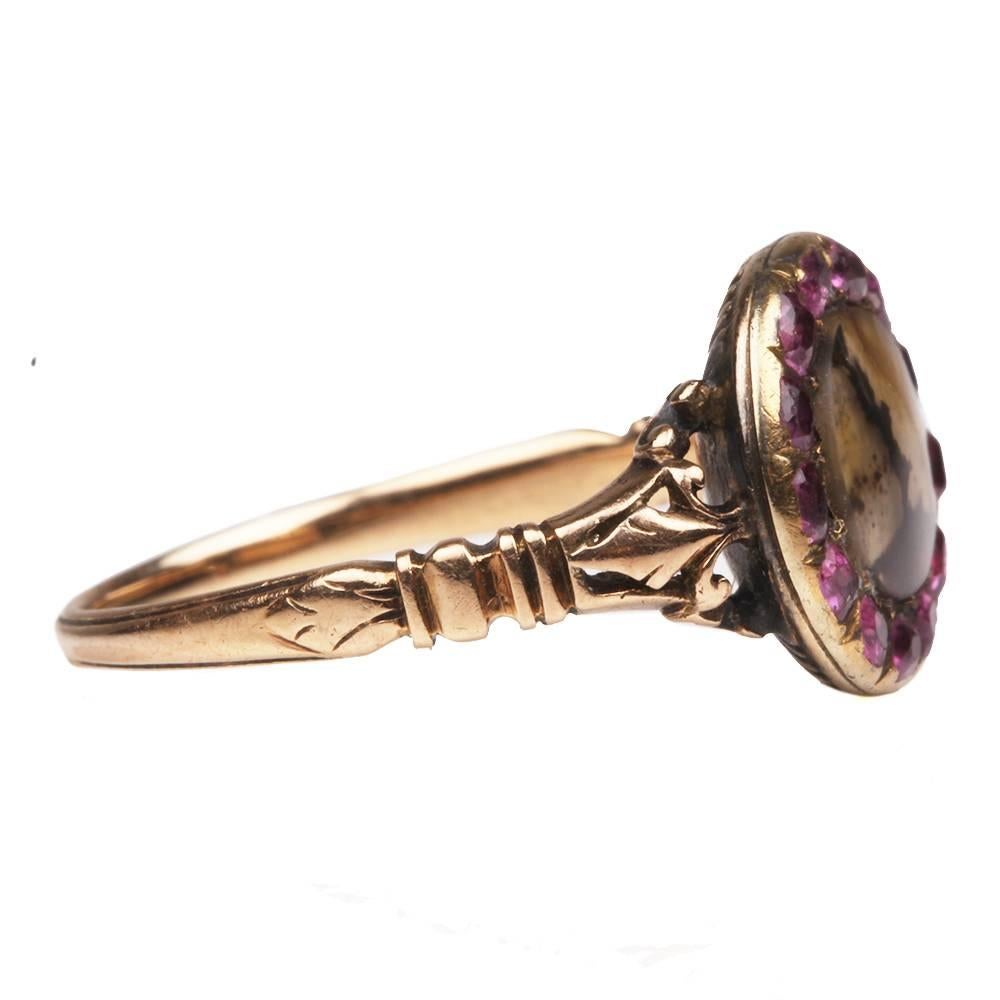 Early 19th Century ruby and moss agate cluster ring, in gold. It has a closed back style setting which is typical for Georgian ring. Beautiful reeded detail on back of setting. Gold fleur-de-lis details flanking the center stones. English in origin.